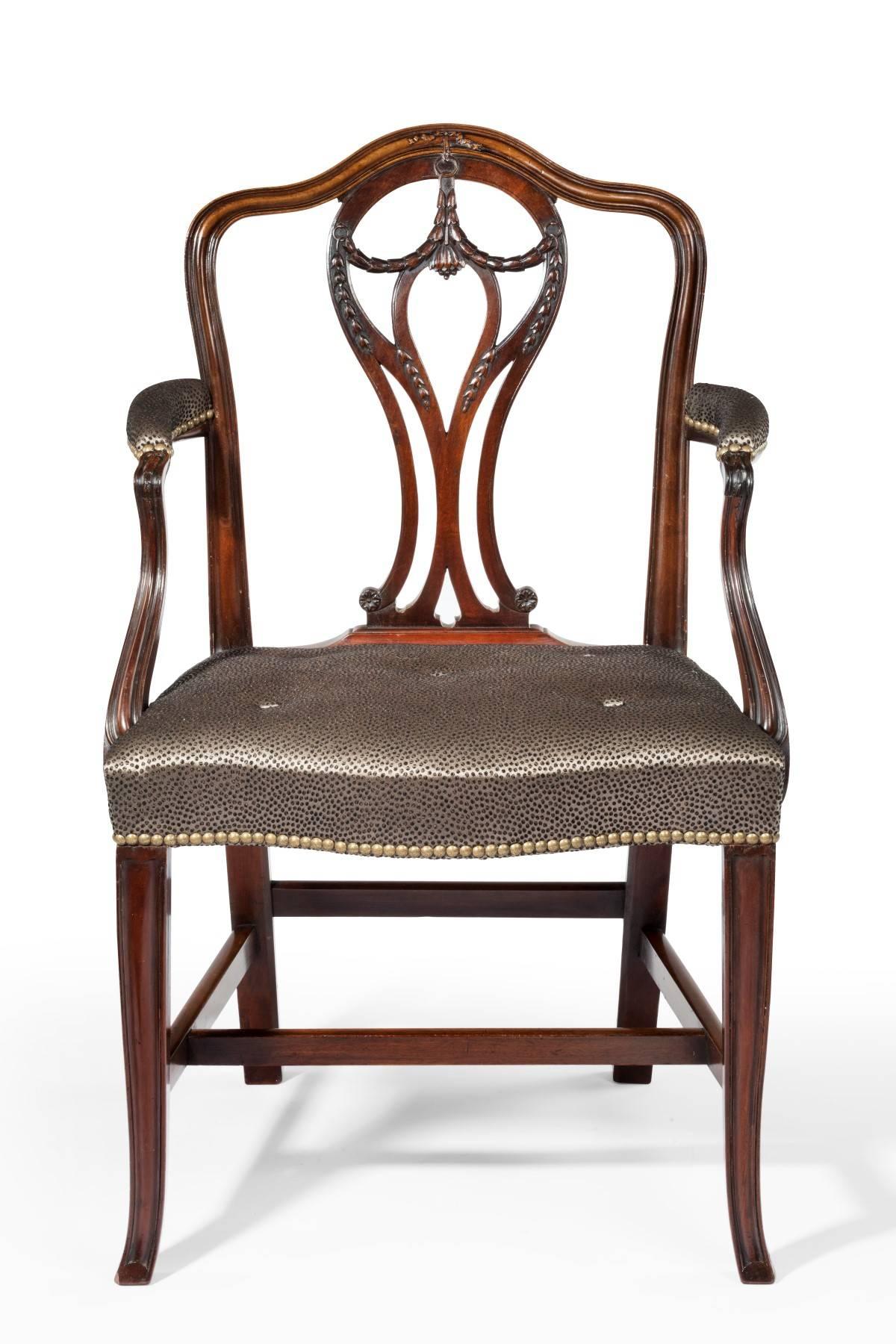 Dating from the 18th century Hepplewhite period and made from best quality Cuban mahogany, the chair has good carved decoration to the back and arms. The molded legs kick out at the bottom and the chair is a very good color. It has been recently