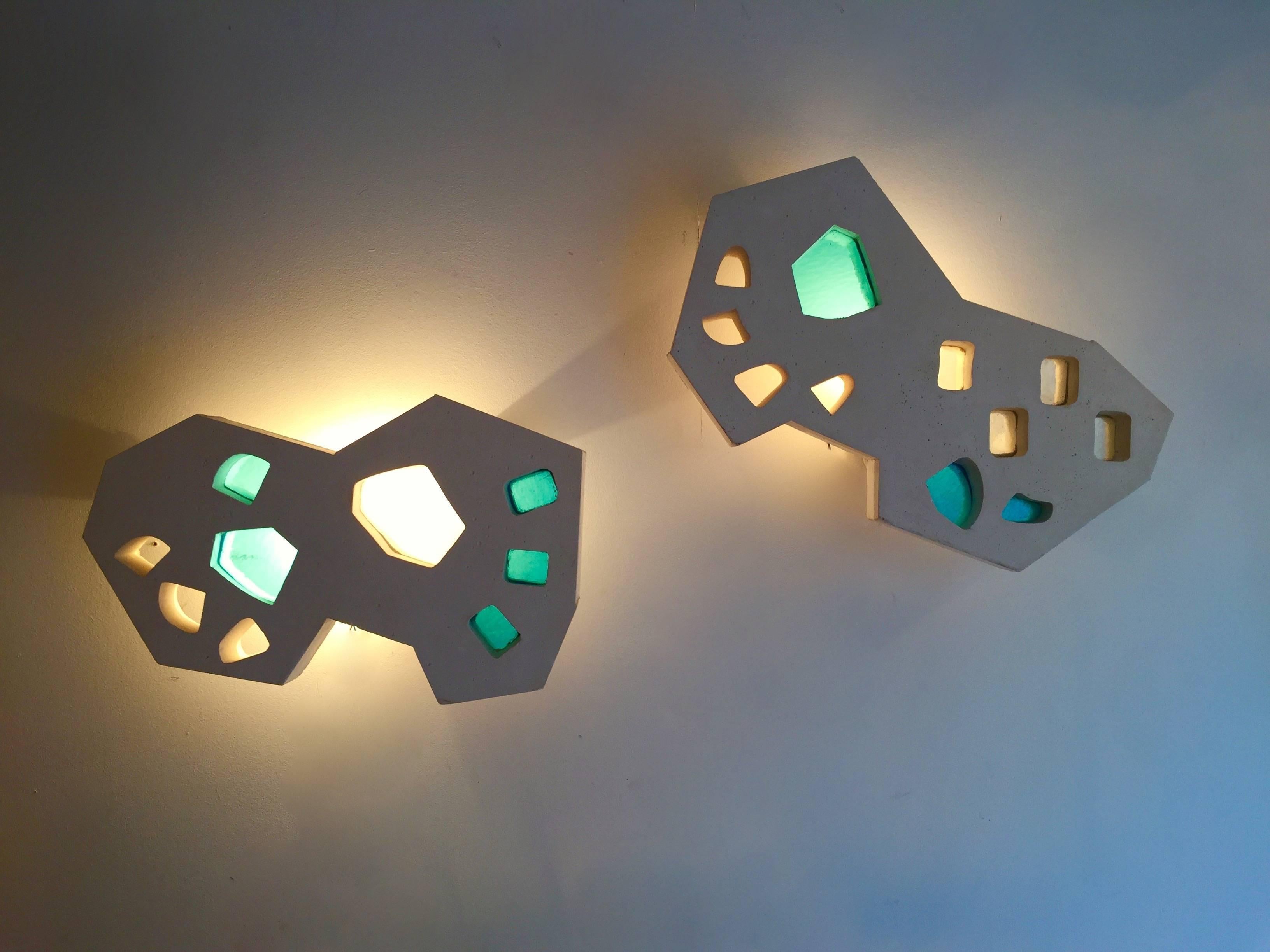 Brutalist and sculptural contemporary work by Atelier Meto, French workshop. The sconces are made in plaster with bleu stained glass. Each piece are different but enough coherent to form a real pair. Few an exclusive production, unique piece each