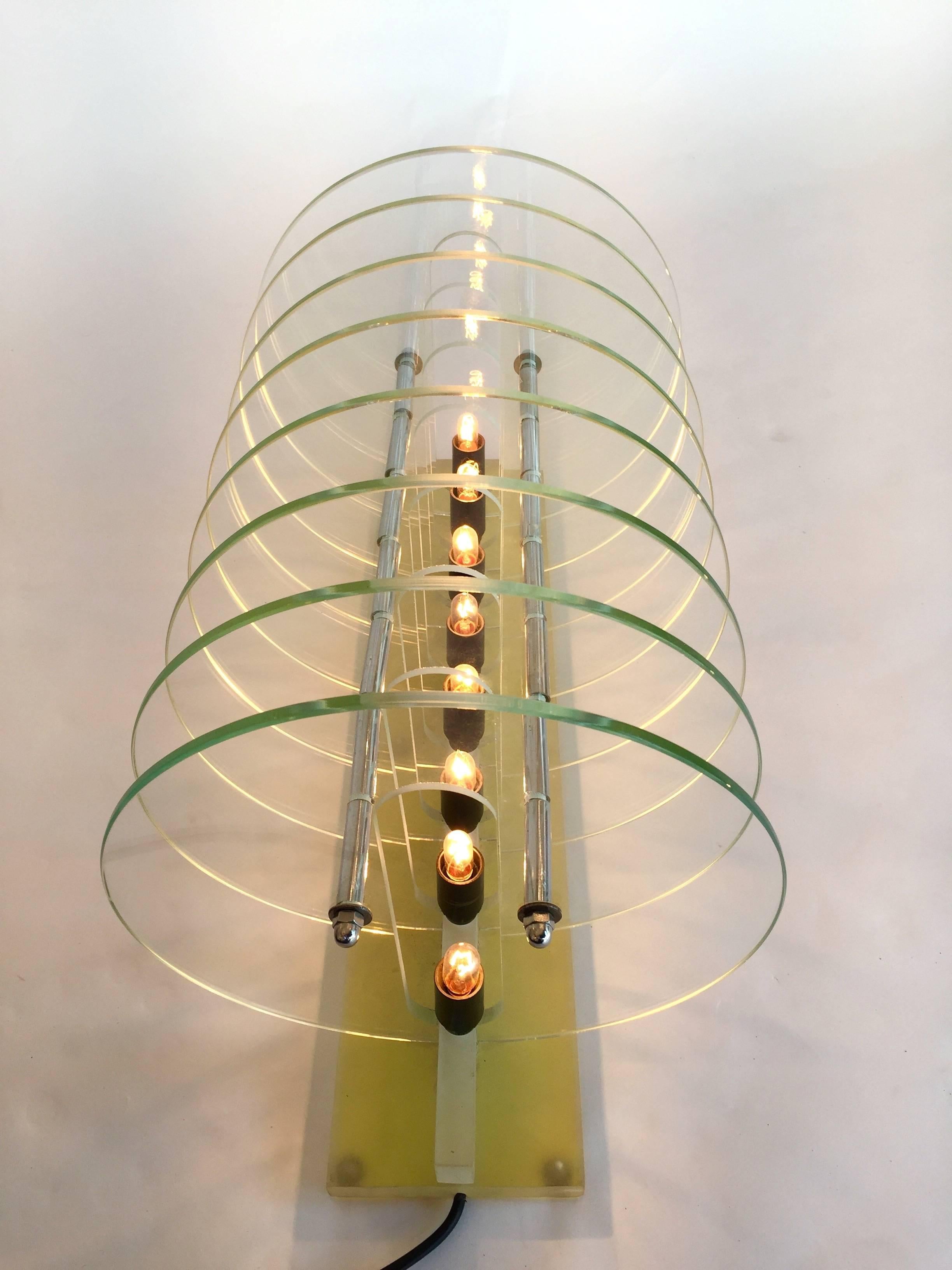 Rare and unusual kinetic or optic table lamp with glass concentric disc and Lucite. Attribute to a small Italian design production close from Memphis, Arditit group, Archizoom style. Really interesting game of light, light extend to infinity.