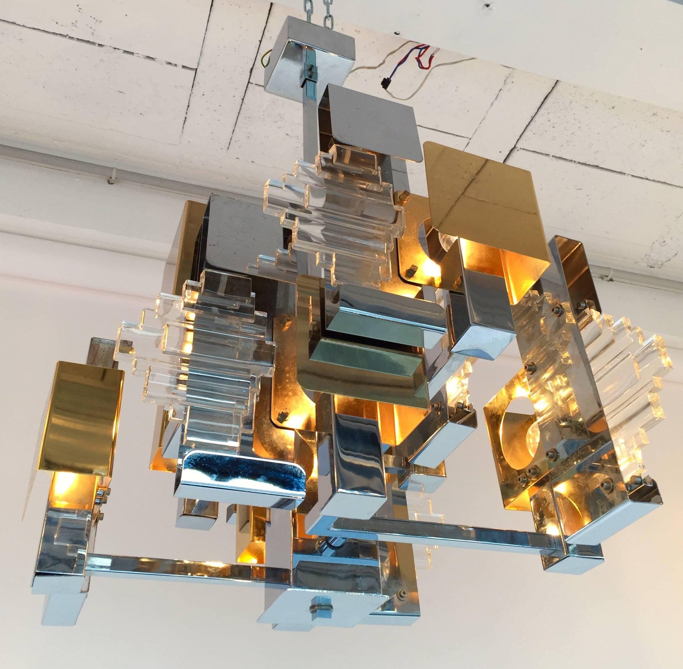 Rare chandelier or ceiling pendant light by the designer Gaetano Sciolari. Small really interesting model by is complexity of composition. Chrome, brass and glass. Very modernist and sculptural.
Sciolari is a famous manufacture like Reggiani,