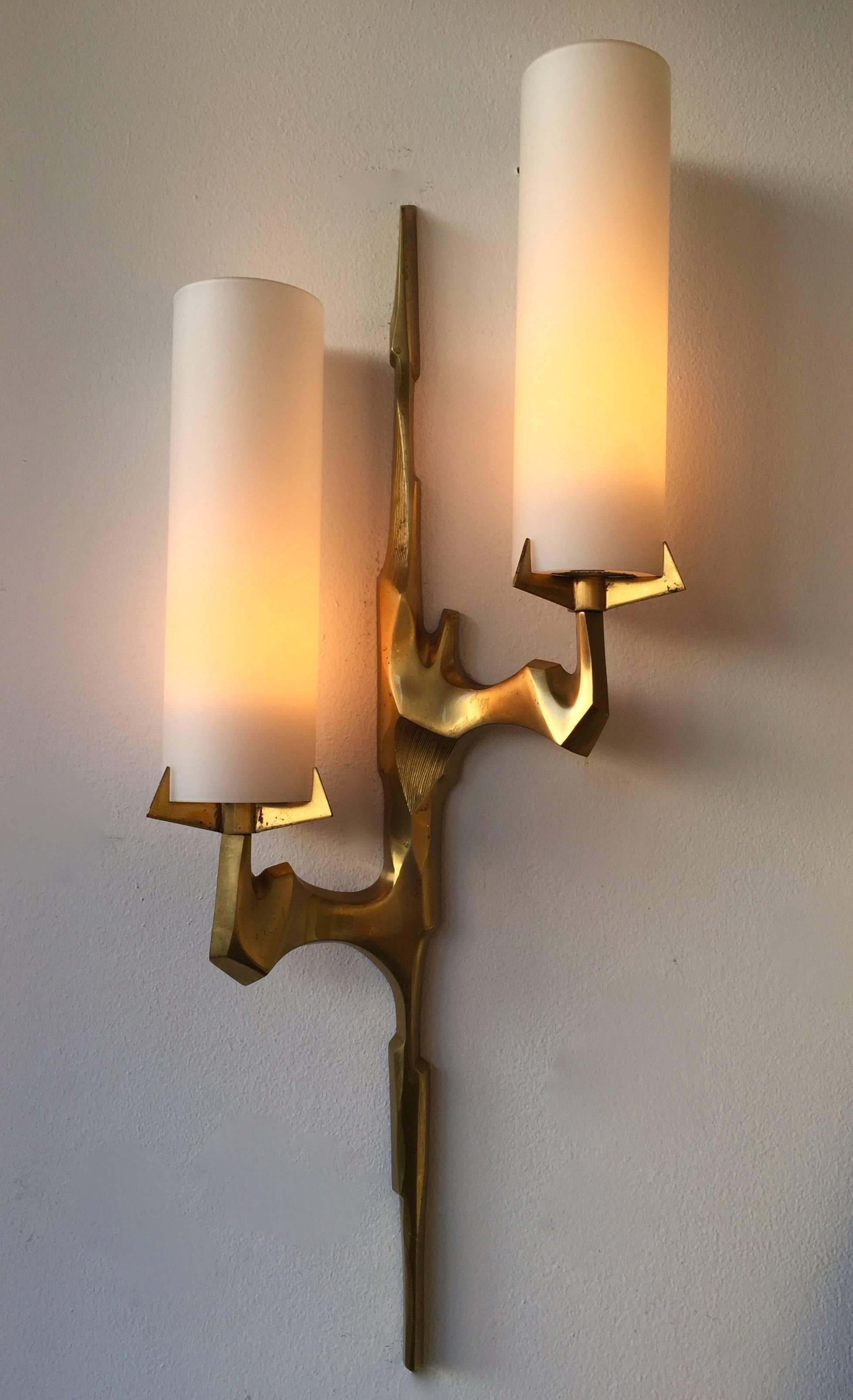 Mid-Century Modern pair of sconces or wall lights by Maison Arlus based on drawing of Felix Agostini for the manufacture. In cast gilt bronze, very interesting and sculptural model. Original opaline glass tube in perfect condition. Original