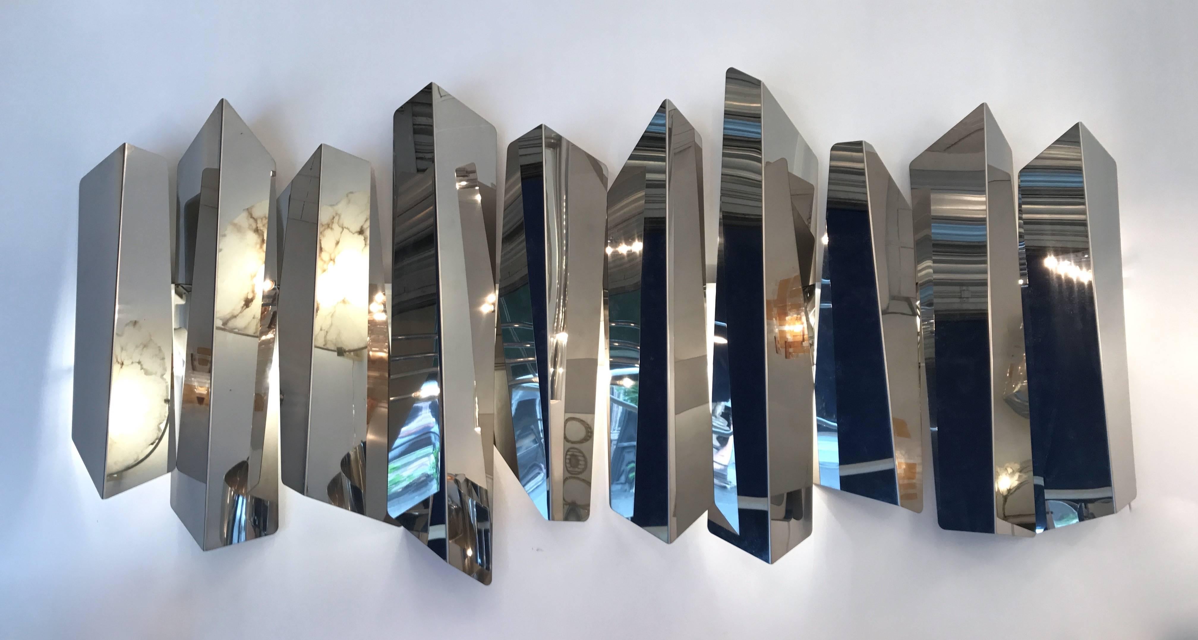 Huge impressive and extremely decorative sconce or wall light panel by the designer Mario Torregiani. Each blade of polished stainless steel are different and retro light by ten bulbs. Simply, each blade is disposed on a single wall plate. Famous