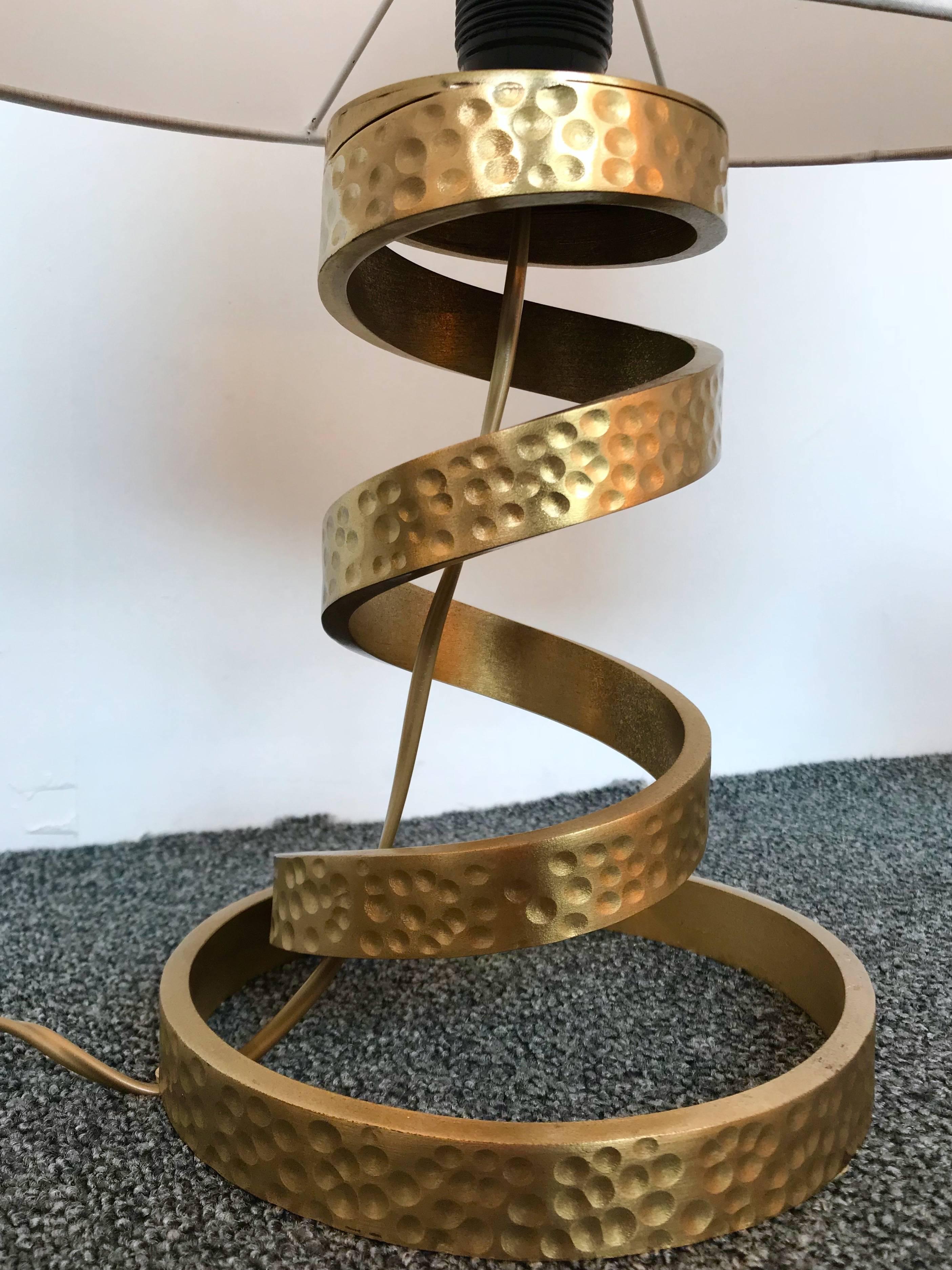 Spiral pair of table or bedside lamps by the designer Luciano Frigerio. Hammered brass maybe bronze. Measurement Height feet 29 centimetres. Note: Demonstration shades not included. Famous designer like Angelo Brotto, Esperia, Tommaso Barbi.