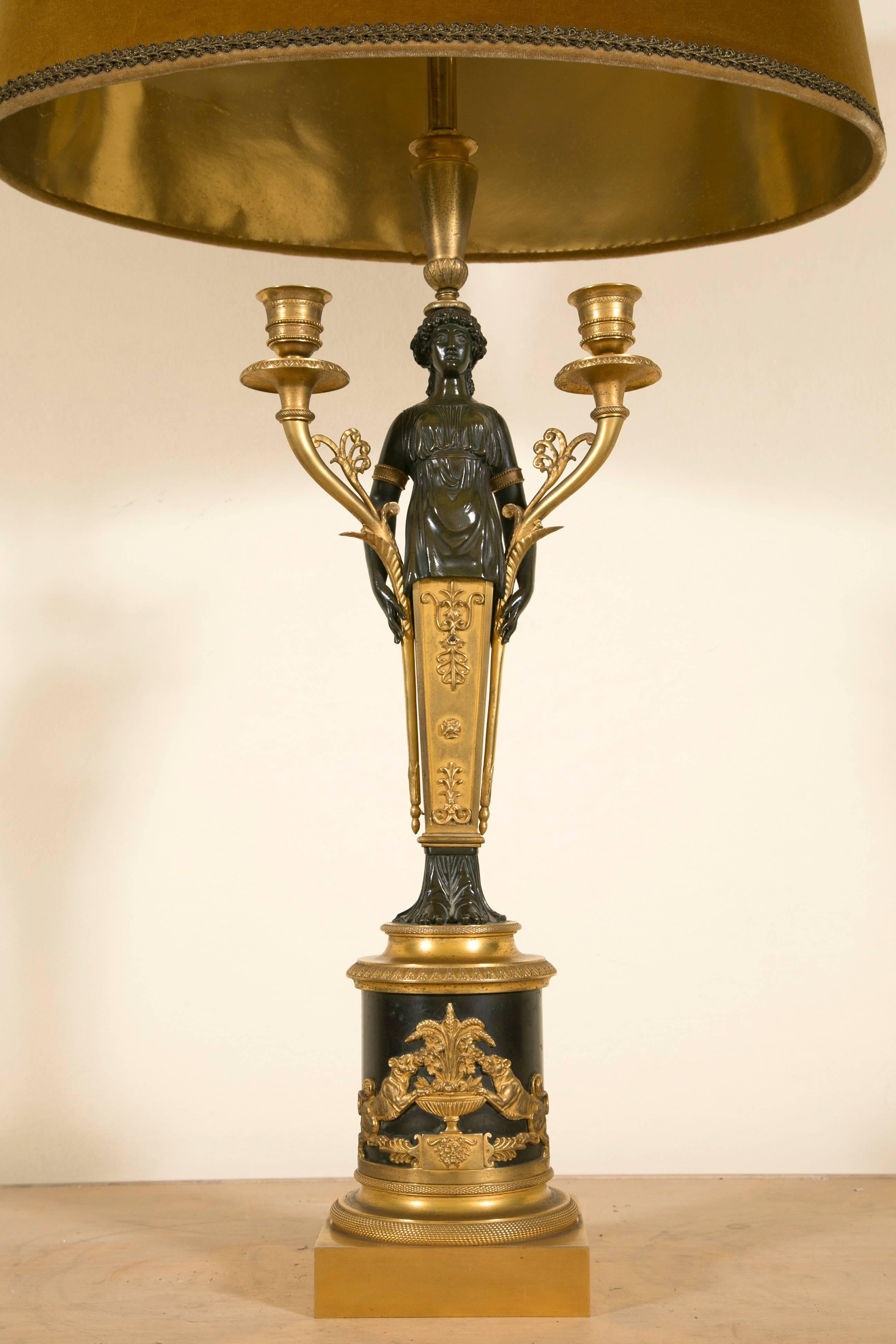 Very rare Empire style lamp base gilt and dark bronze, beautifully executed model with fine attention to details. The woman holding the two branches presents a nice smiling face and wears a delicate draped dress.
On the base the two gilted lions