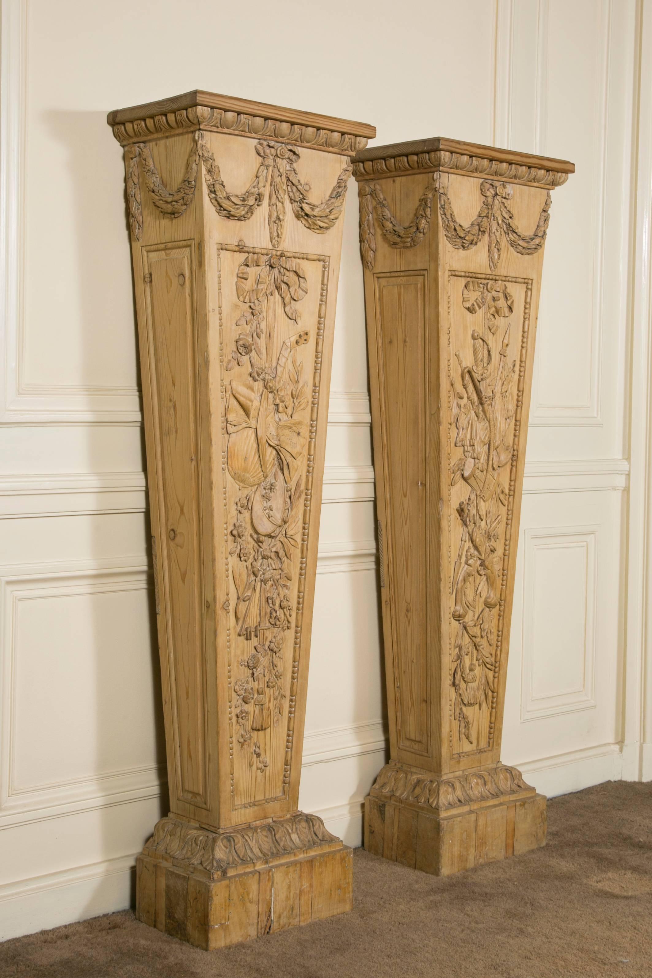 Very fine and rare pair of pedestals in pinewood, with different carving on each one representing drum, tambourin, horn, mandoline, flags, pistols, sabre, ribbons with tassels etc. and different leafs and flowers.
