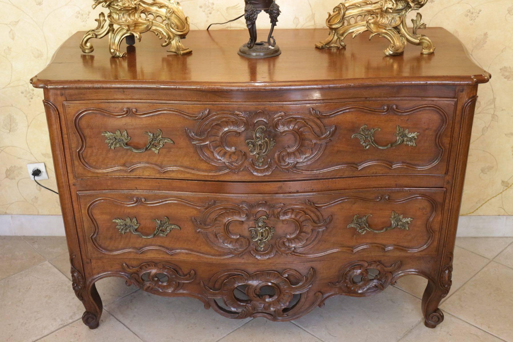 French 18th century walnut commode two drawers with rich carving, exceptional open carved bottom belt and snail feet.