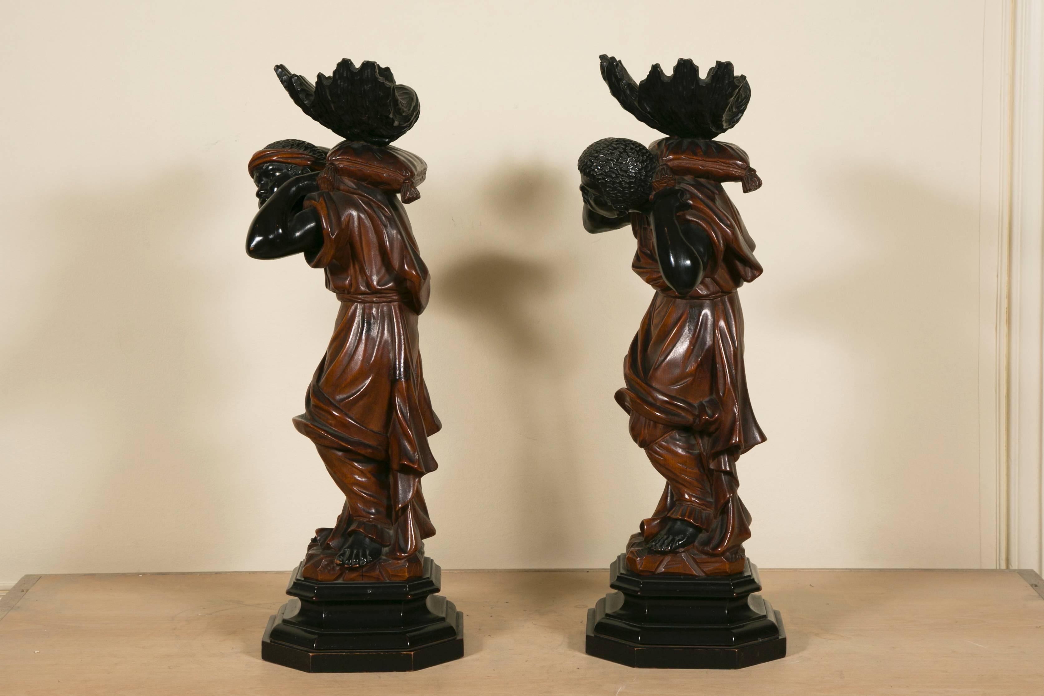 Exceptional and rare pair of 19th century wood carving figures beautifully executed with lacquered eyes and two color lacquered on the body. Figures are holding a shell on their back.