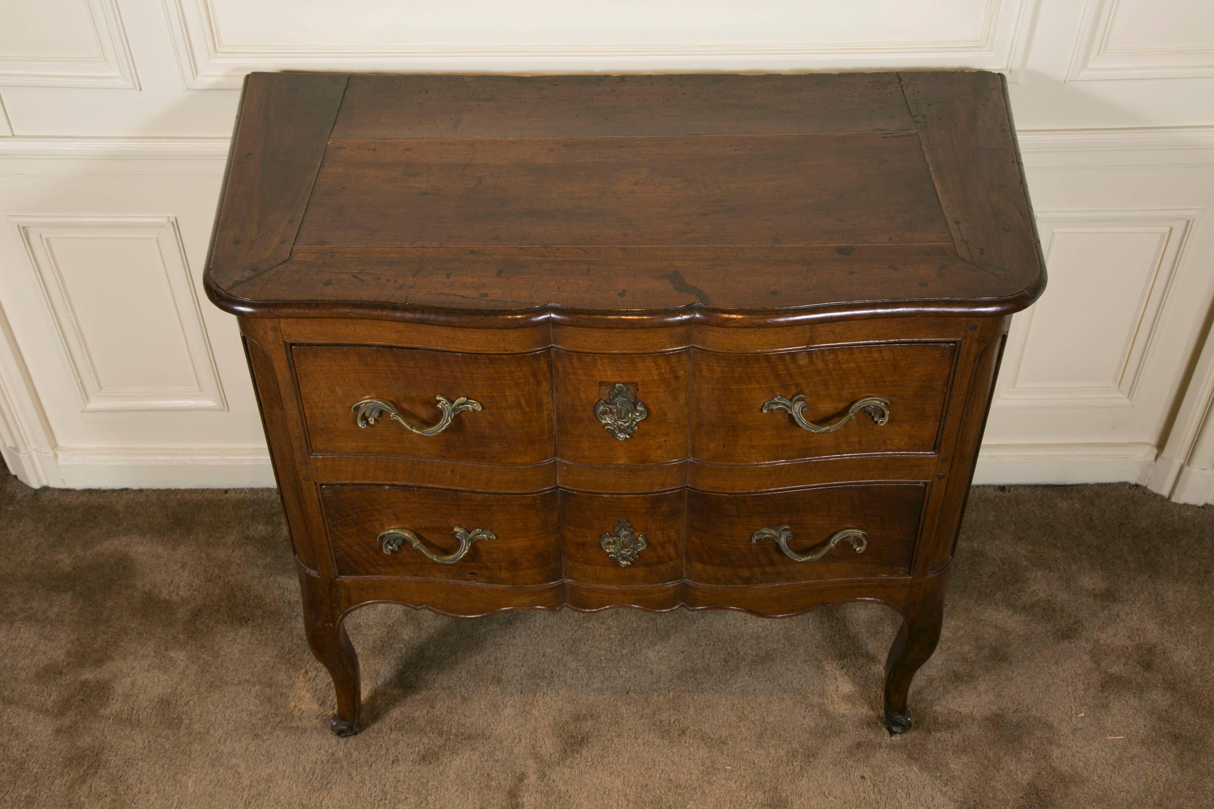 Two drawers commode on high cabriole legs terminated with snail feet, this type of commode is called sauteuse it comes from the town of Grenoble France, in Dauphiné region which is famous for the quality of its walnut. Some local creative and