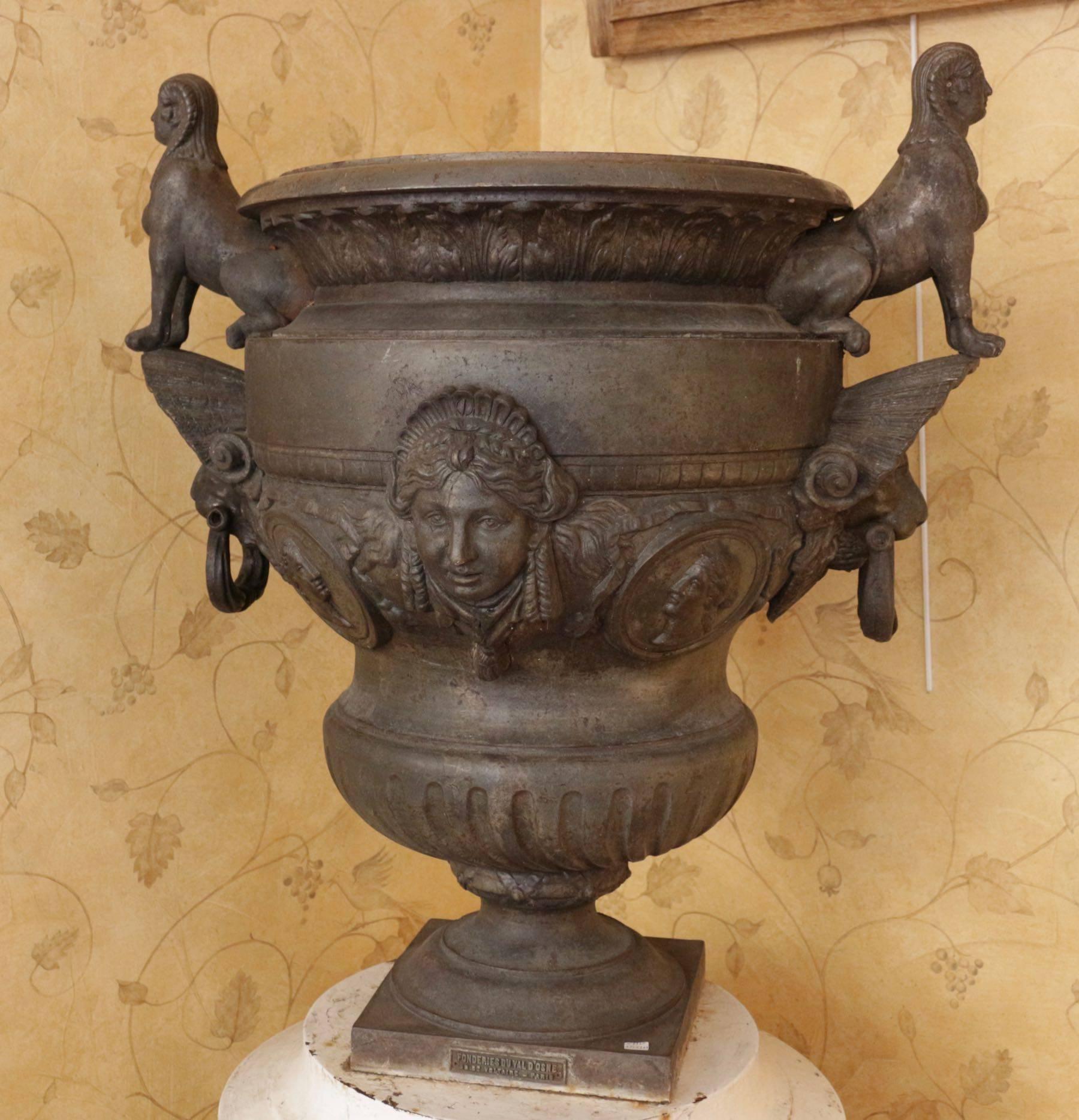 Large cast iron ornament bowl decorated with female Roman heads cartouches and deeply gadrooned on a molded base. On the sides a shelf cover a the lions head which old handles on his mouth and which carry too sphinges standing on
The bowl is