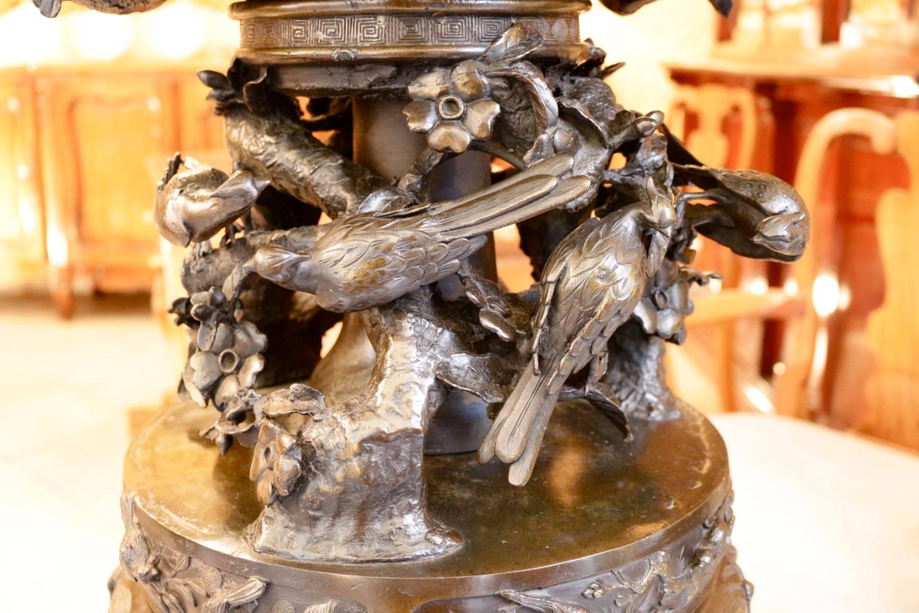 19th century Japanese incense burner with 15 bronze birds in haut relief on branches and foliage in the middle of a natural scene, ducks and birds are on the bas relief, two cranes on the lid.
The wooden base consists of three elephants head with