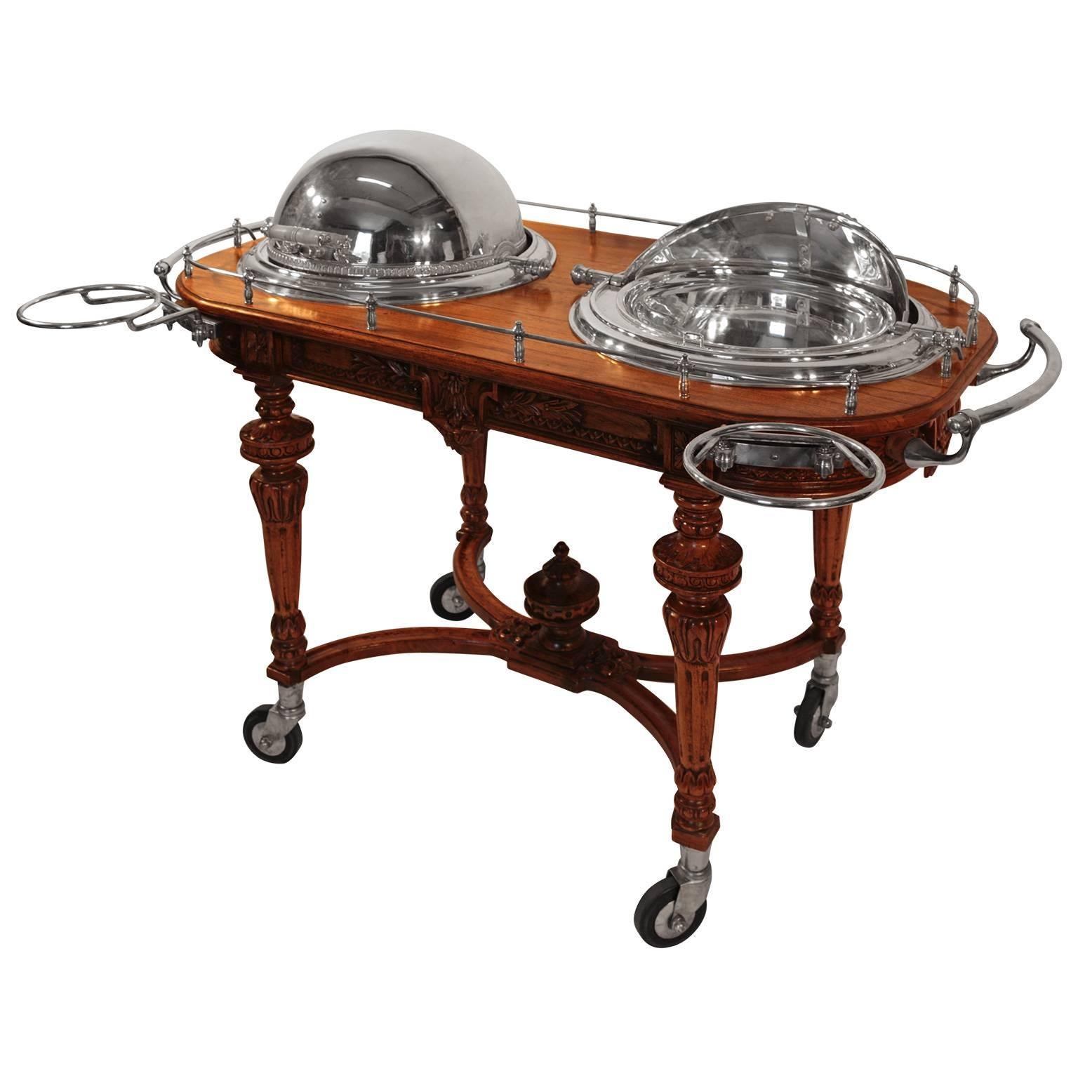 Oak double serving trolley Royal Castle English Sheffield, In the Napoleon III taste, the intricately caved oak base of rectangular form with rounded ends, four toupee legs, fitted with a pair of hemispherical silver plated revolving serving dome.