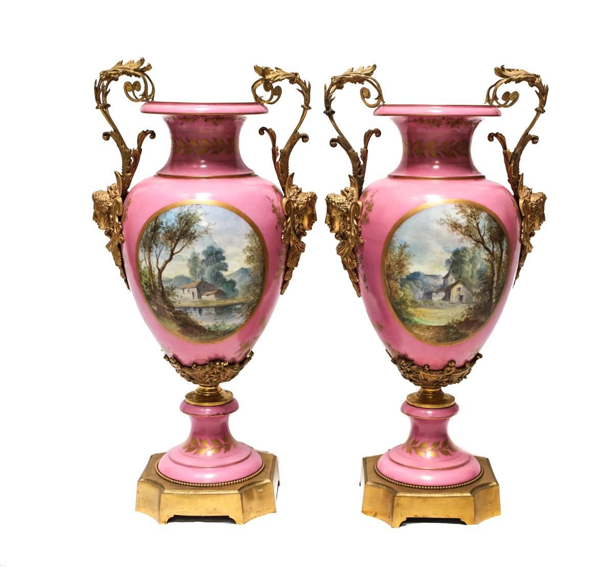 An imposing pair of French hand-painted porcelain urns with gilt bronze mounts. The central reliefs depict hand-painted outdoor scenes after Fragonard, "Blindman's Bluff" and "The See-Saw". Each signed lower right 
A. Maglin.