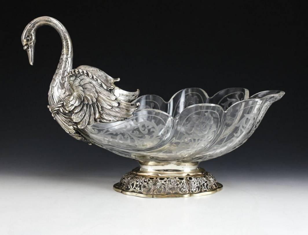 A truly stunning centerpiece trio comprised of solid silver form Swans mounted to cut-glass bowls. Exceptional details to the feathers, each bowl with elaborate hand etched floral designs to the glass, the two smaller bowls with .800 silver webbed