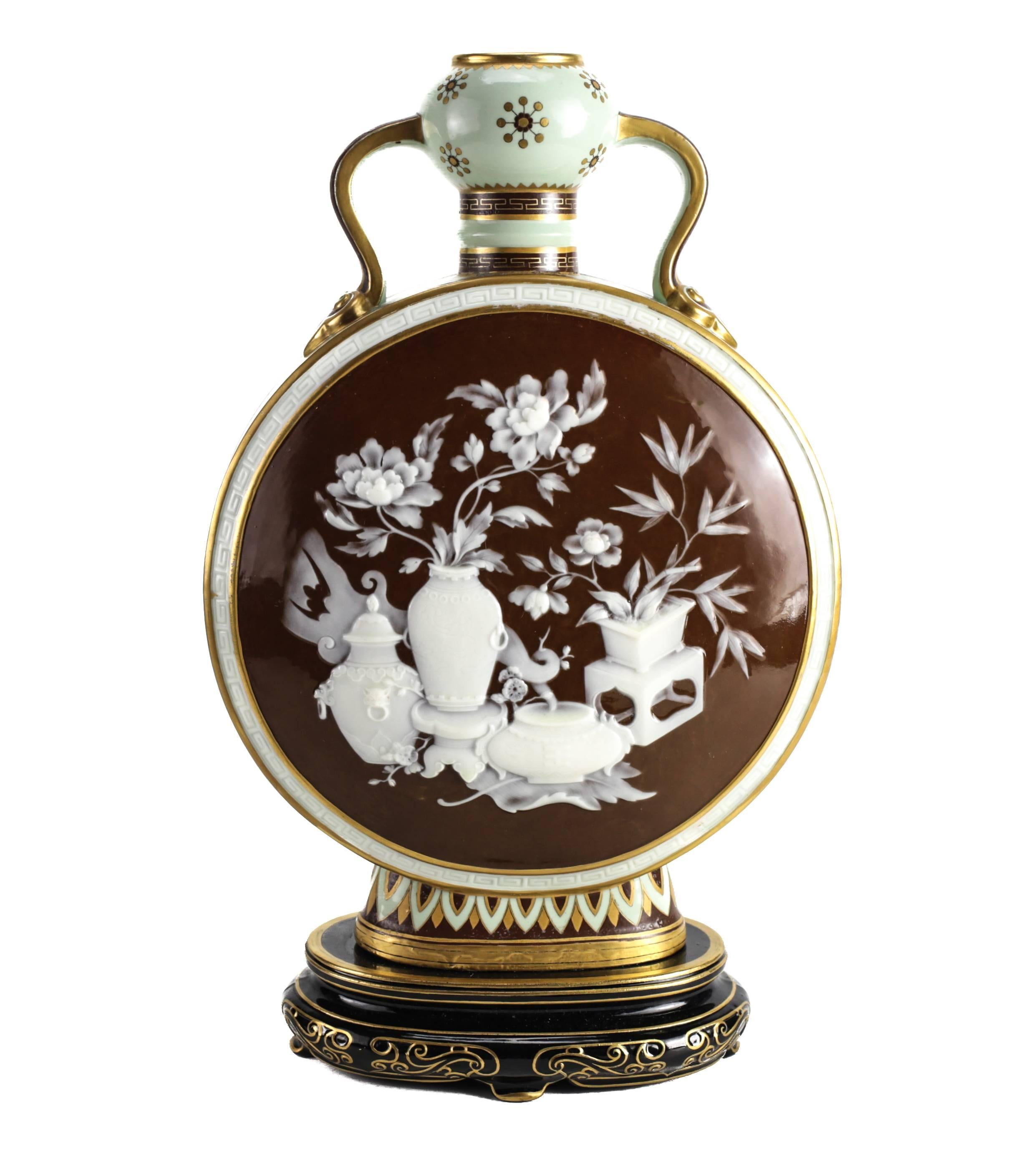A large and impressive moon flask bottle or vase by Minton. Both sides with elaborate Chinoiserie decoration in pate sur pate white slip (paste on paste) on a chocolate brown ground with the faces and hands in beige slip. The shape takes the form of