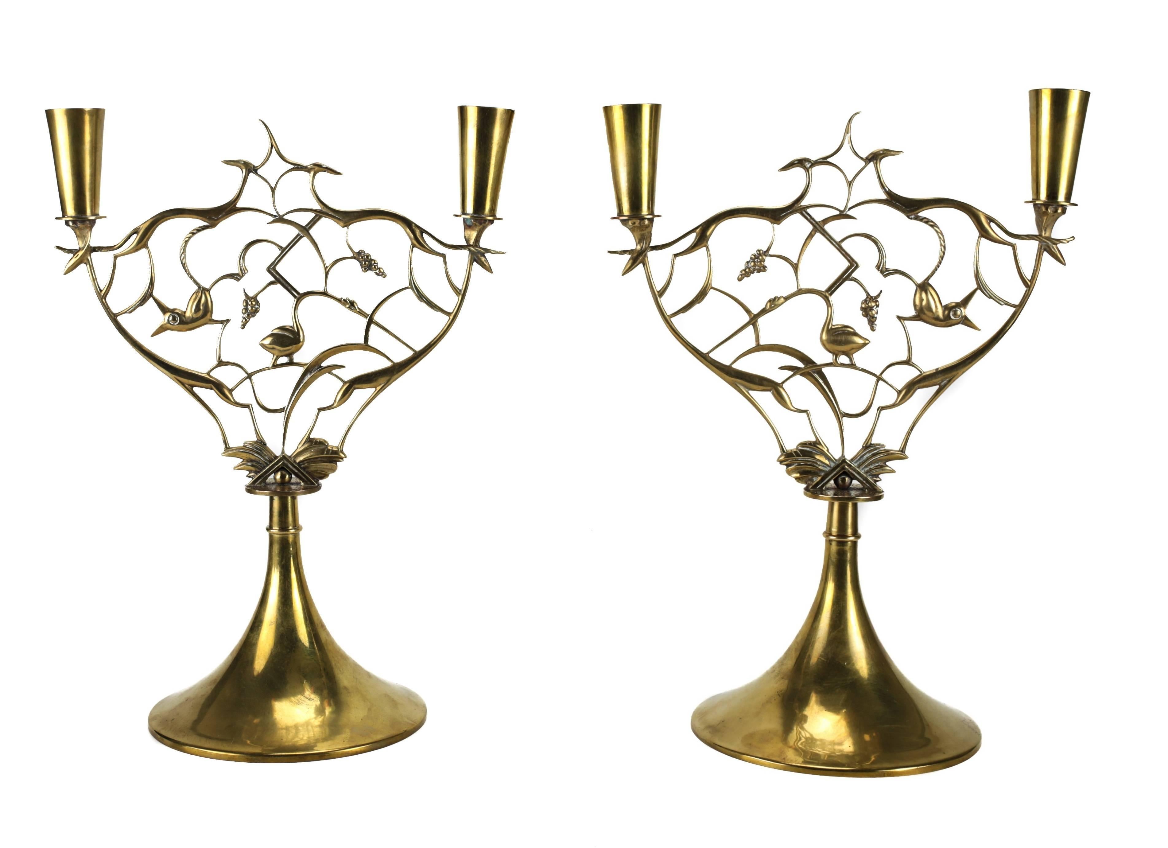 A stunning pair of brass candlesticks with intricate animal integrated vines and grape vine clusters by Karl Hagenauer and produced by Werkstatte Hagenauer. Each signed WHW in a circle.