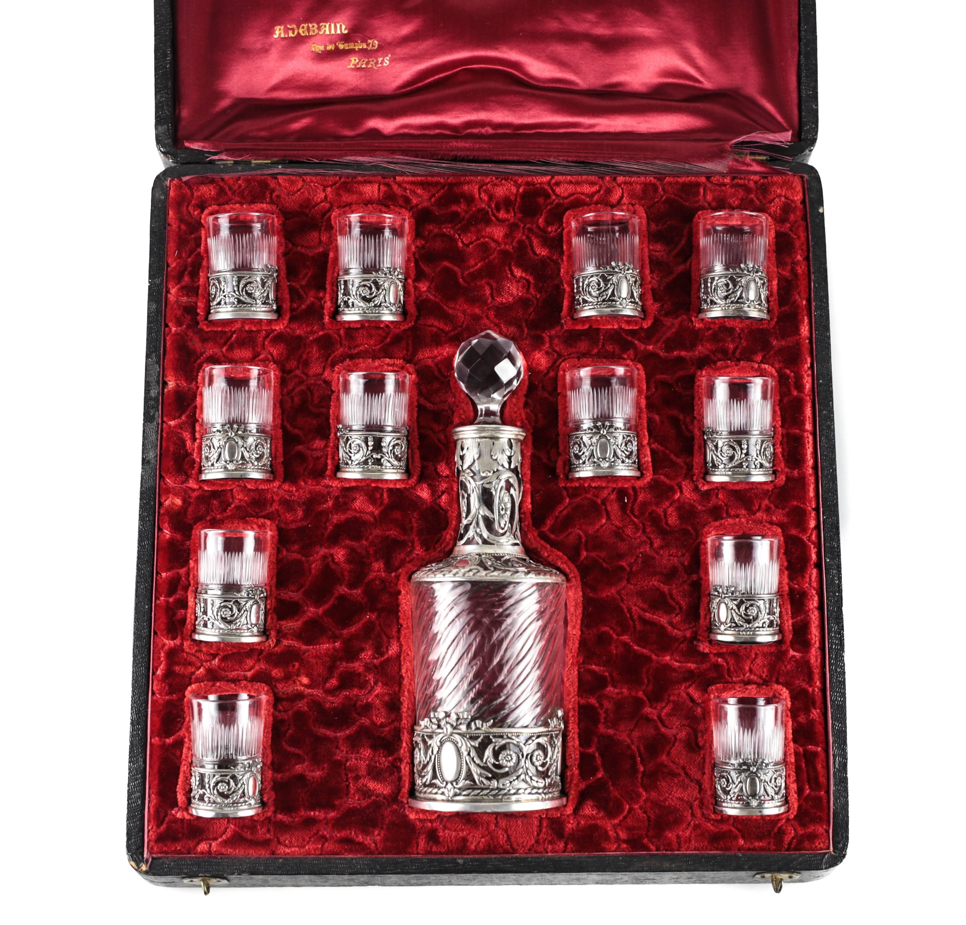 A wonderful cased set of 12 solid silver mounted liquor drinking glasses with matching decanter. The set has incredible hand chased details to the silver with floral vines and sprays, etched fluting to the glasses.

A stunning leather lined wooden
