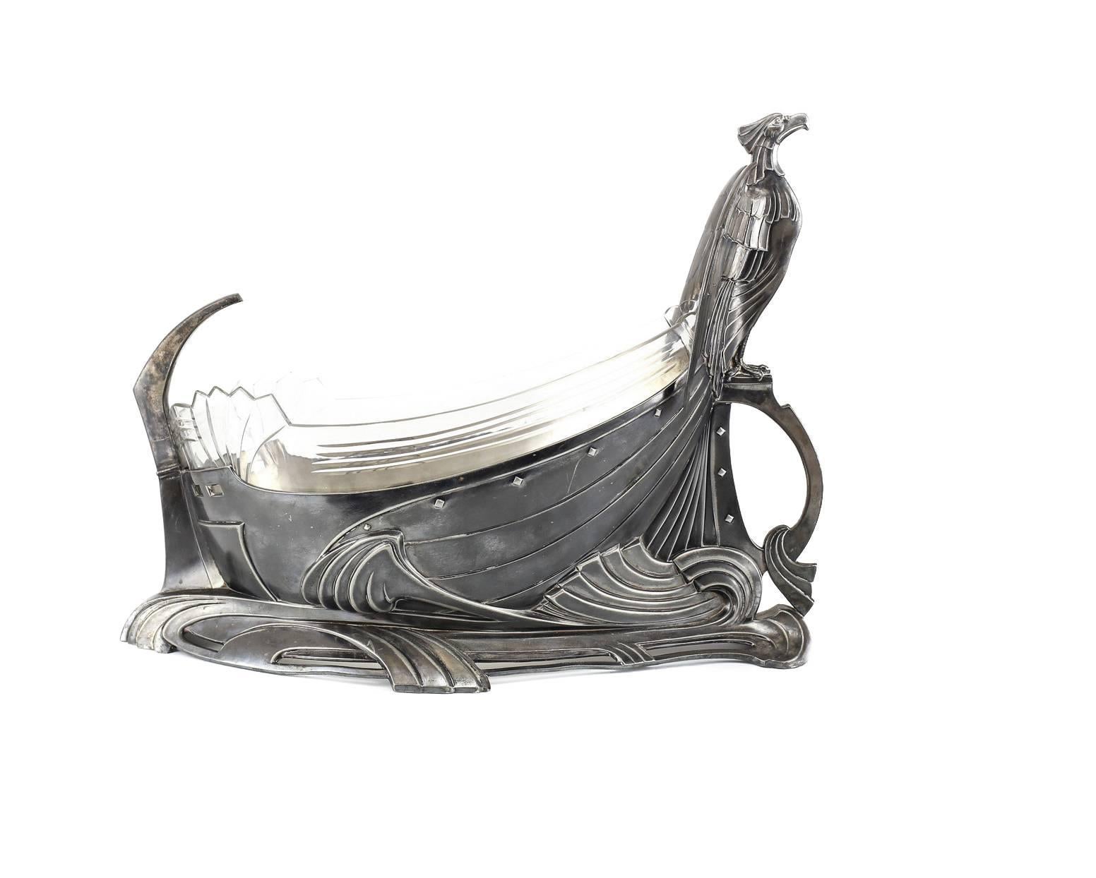 An impressive Arts & Crafts centerpiece bowl by Wurttembergische Metallwarenfabrik (WMF) taking the form of Viking ship. The bow prominently cast with a perched Griffin, beautiful conjoined waves creating a sense of movement. The original
