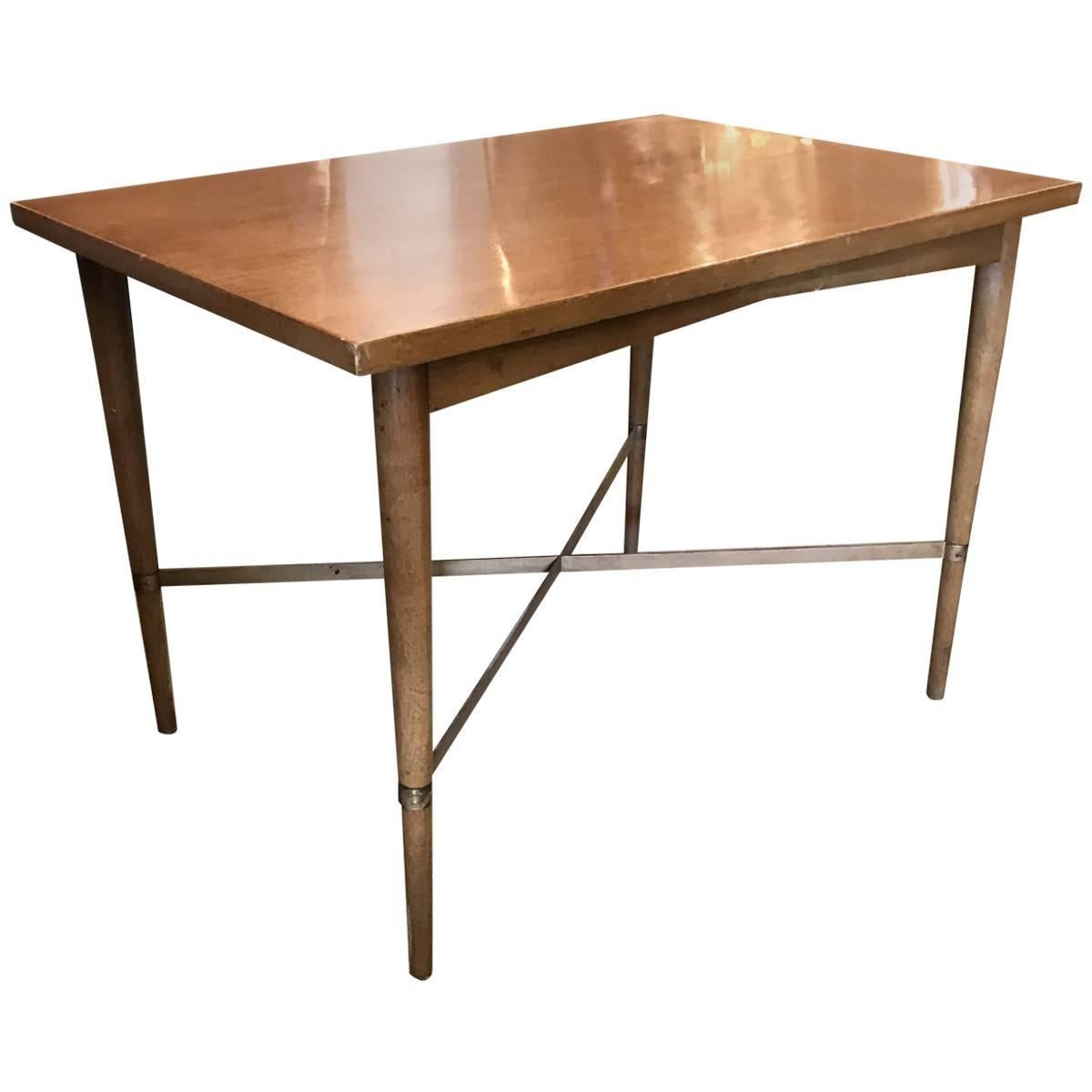 This exquisite stained mahogany and brass side table, designed by American Mid-Century Furniture and Industrial designer Paul McCobb, was manufactured by H. Sacks and Sons. It features clean, simple lines, and brass X-shaped stretchers connect its