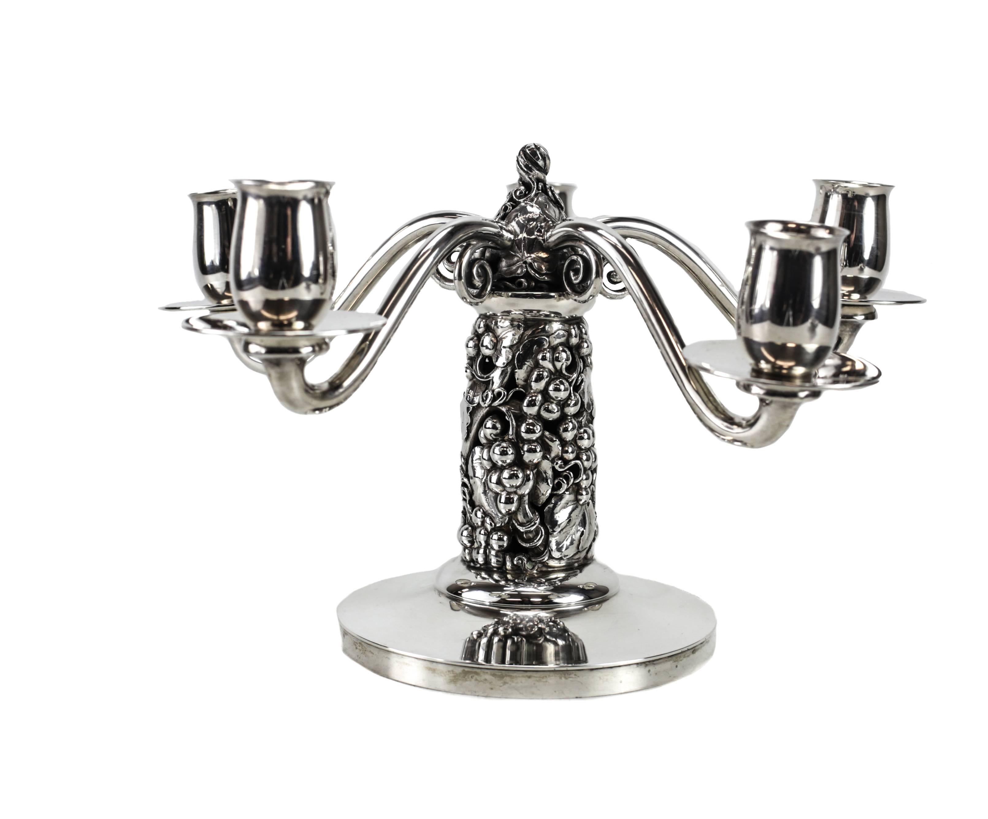 A sterling silver candelabra, beautifully executed in a fruiting grape vine motif with five arms, designed by Johannes Siggard and executed by Evald Nielsen. 

Impressed marks include:
Three tower mark indicating sterling silver, with 34 for