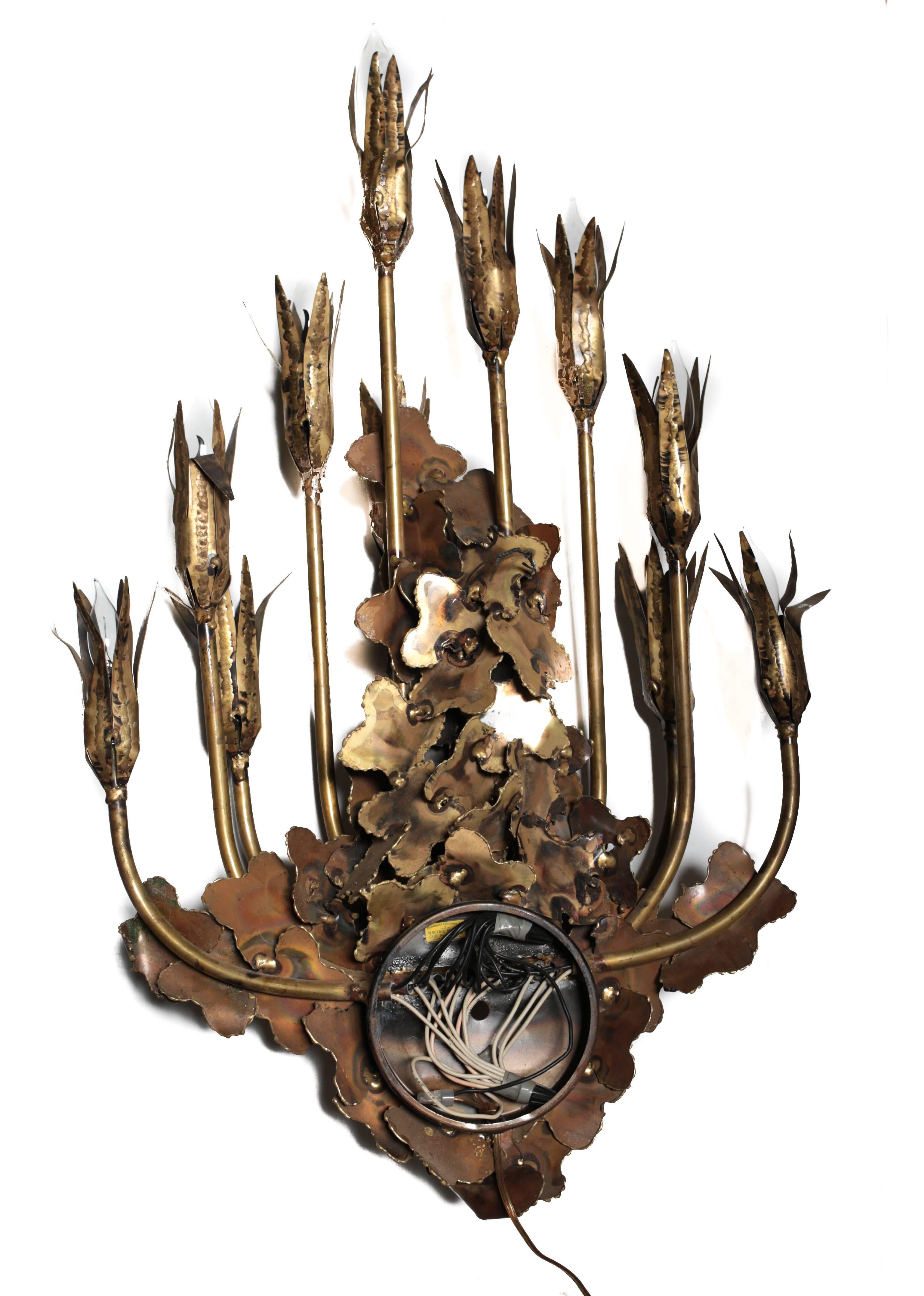A beautiful polished and patinated brass candelabra wall sconce in the Brutalist manner designed by Tom Greene, circa 1960.
  