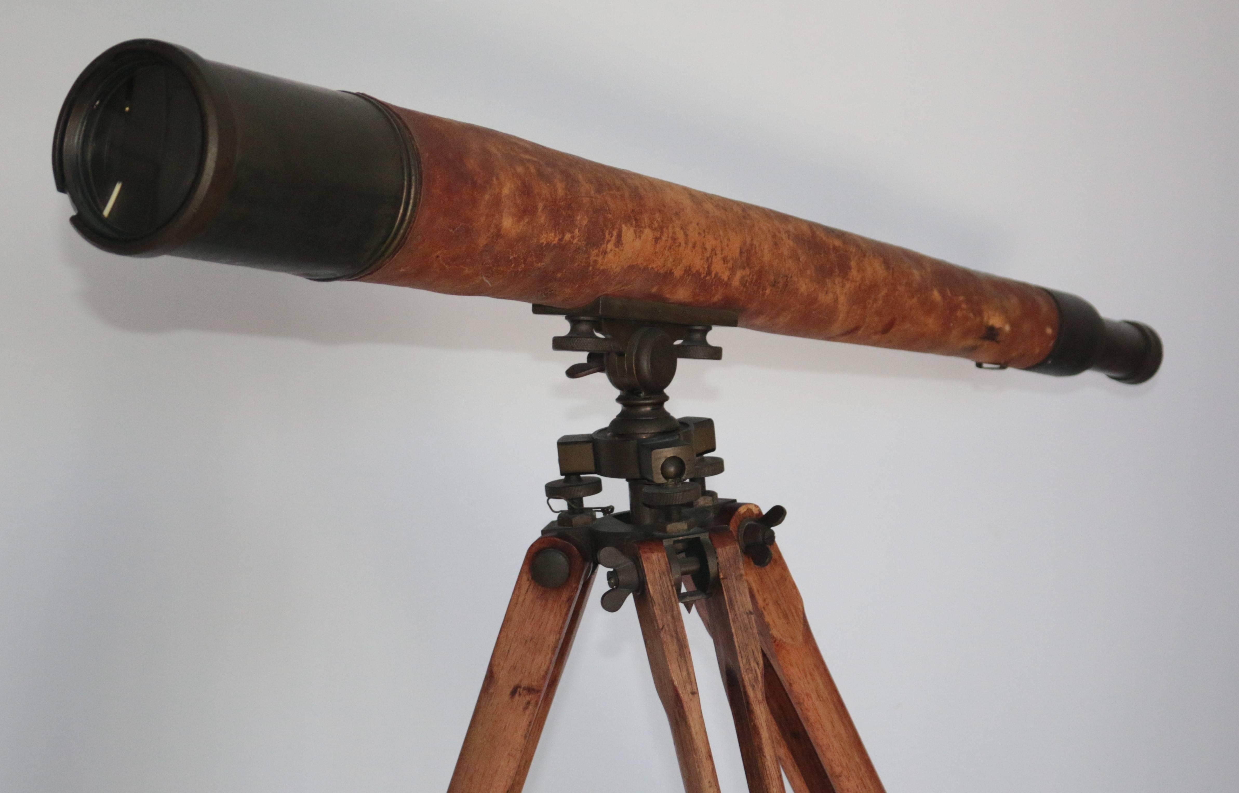 This decorative telescope stands on a height adjustable base which was designed to be used outside because of the spiked feet. The Scope itself is brass with a stiched leather covering to the centre section and bears stamped markings.

Height will