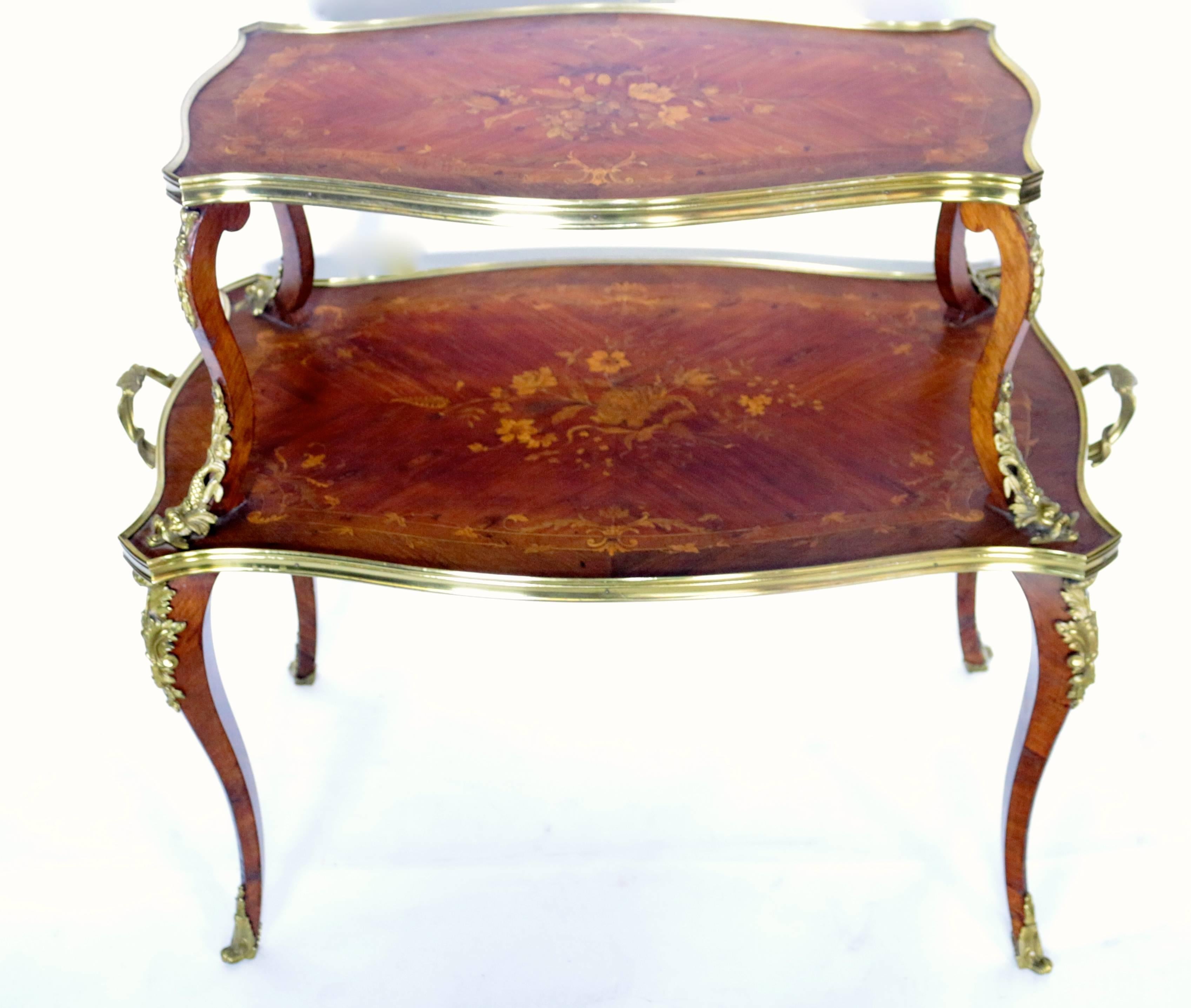 This elegant and beautiful two-tier table if magnificent. The floral design is hand-carved into the table and is lightly colored in to show subtle hints of the design. What catches the eye the most is the handmade brass molds and lining. From the