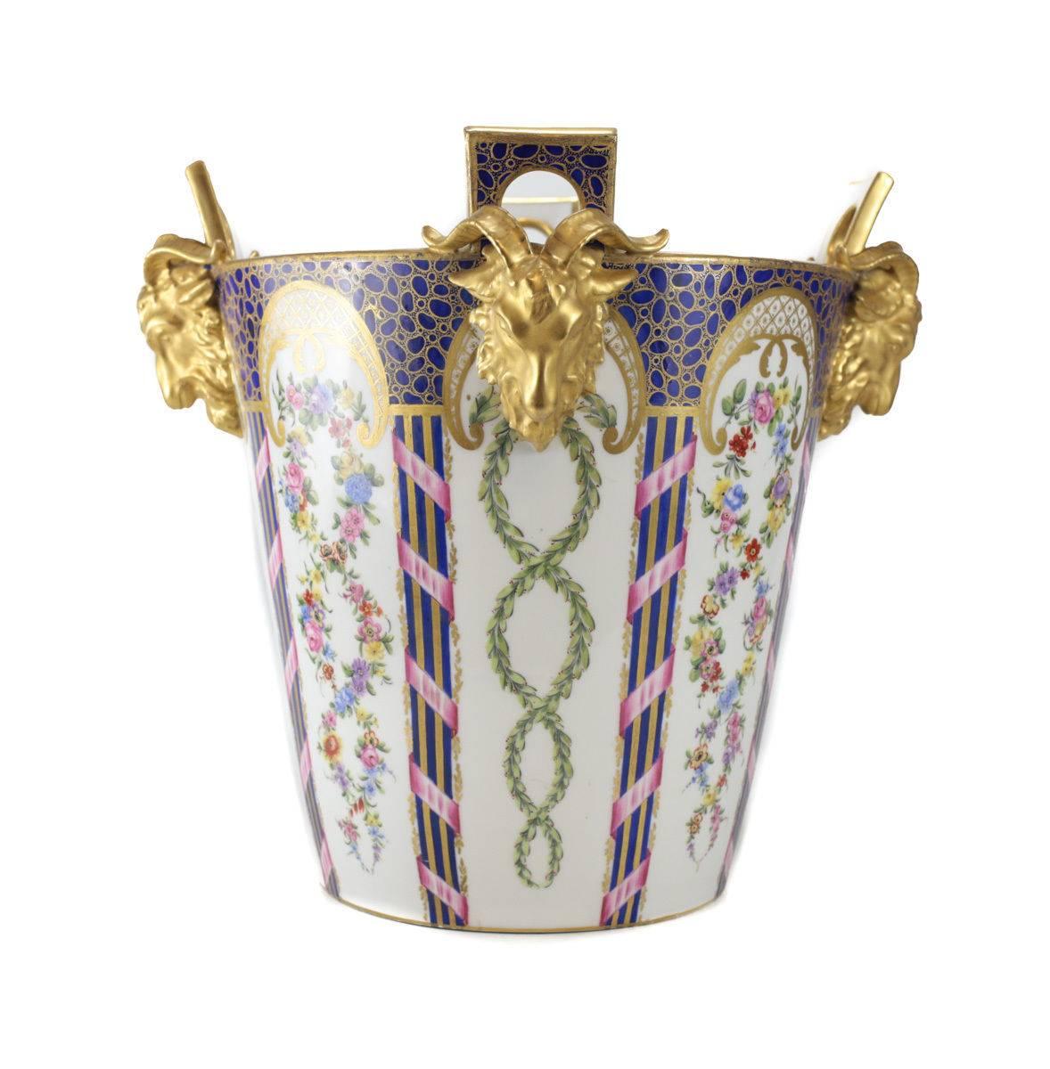 A very large late 19th century Sevres porcelain jardinière cache pot or milk pail, with gilt goat head handles. Finely hand-painted pink roses, green leaf garlands and cobalt blue and gilt designs. Signed with interlaced L's to the underside.
