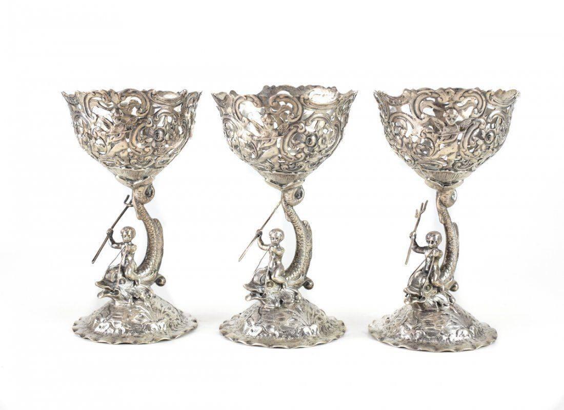 Group of six B. Neresheimer & Sohne German .800 silver figural compotes. All with cherub and dolphin stem figurals, with three holding tridents. Marked with German Hanau silver hallmarks. Weight approx., 10 ozt to each compote.