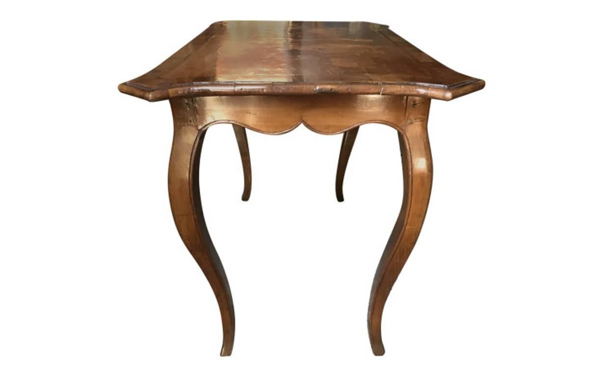 A collectible piece from bygone days, featuring the finest craftsmanship, materials, and design elements of its given era. Sleek but ornate, this circa 18th century table is crafted from walnut and features elaborate inlay detailing. Hand-carved