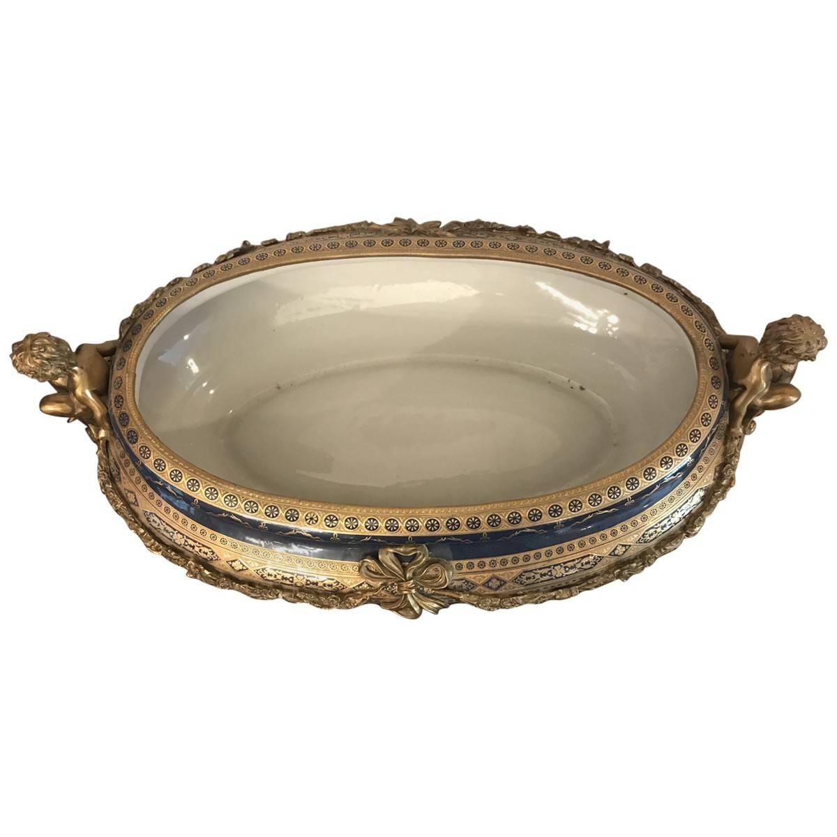 Timeless elegant and ornate centrepiece, this commanding porcelain bowl is mounted on an elaborately detailed bronze base. Cobalt glaze and gilt enamel highlights ensure this circa 20th century centre bowl looks sophisticated on any surface.