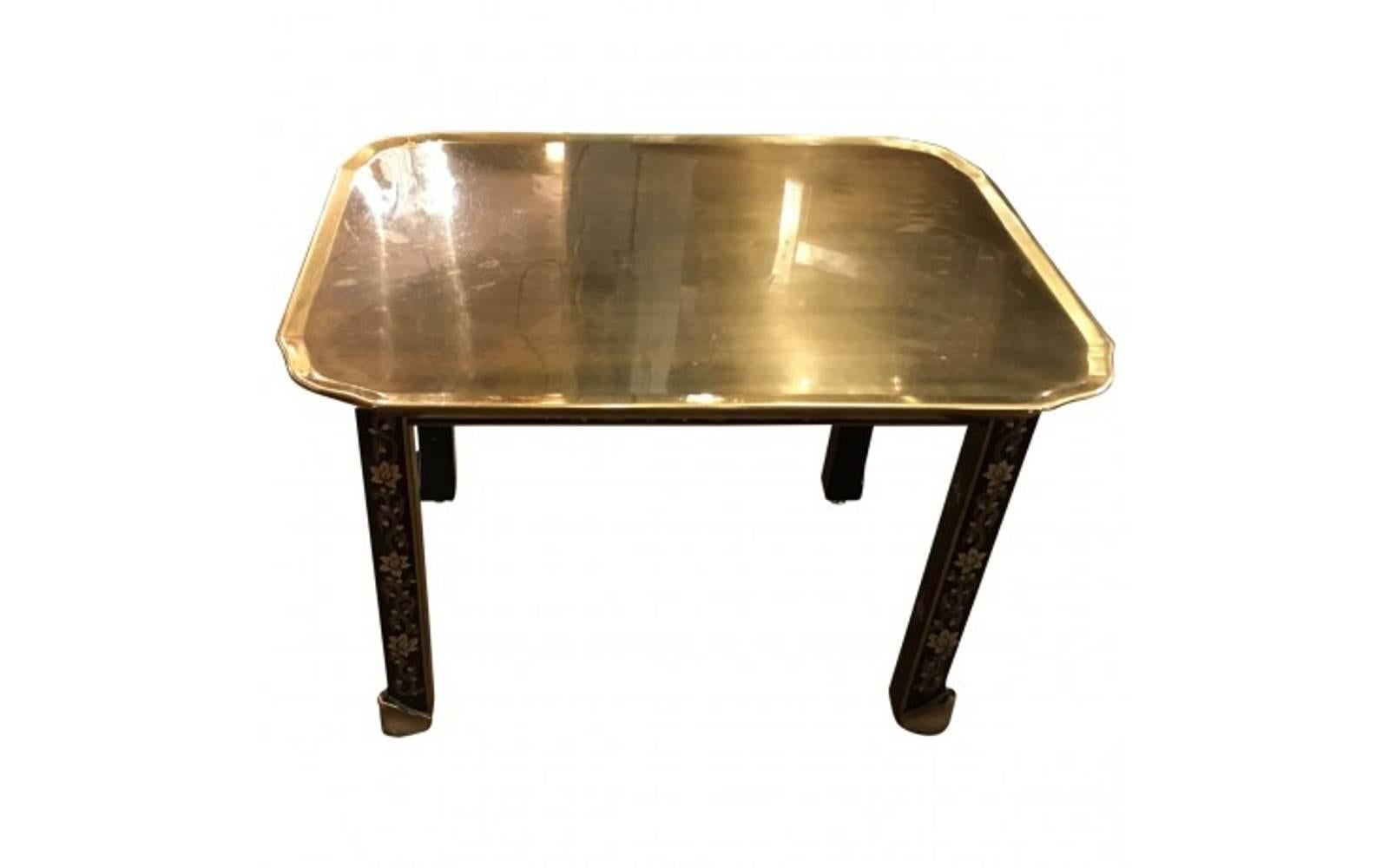A Classic vintage piece from the 1950s, this elegant side table features a gleaming brass tray top supported by slender legs decorated in a charming floral pattern. With its understated modern design and romantic accents, this table provides a