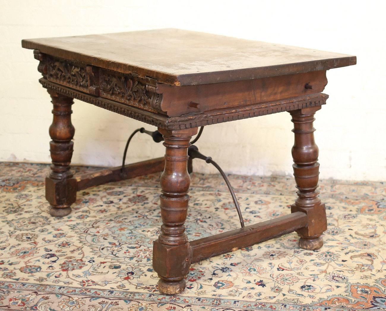 18th century Continental rustic desk (Italian possibly) with iron supports, two drawers, hand-carved details. Baluster turned legs, bun feet. Original finish.
