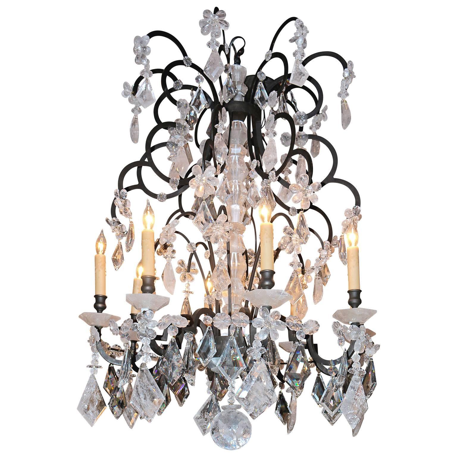 Pair of Impressive rock crystal chandeliers in good used condition. Rock crystal bobeche chandelier have a subtle touch of smaller crystals. The column of this chandelier is made entirely of rock crystal and is connecting the top tier to the bottom