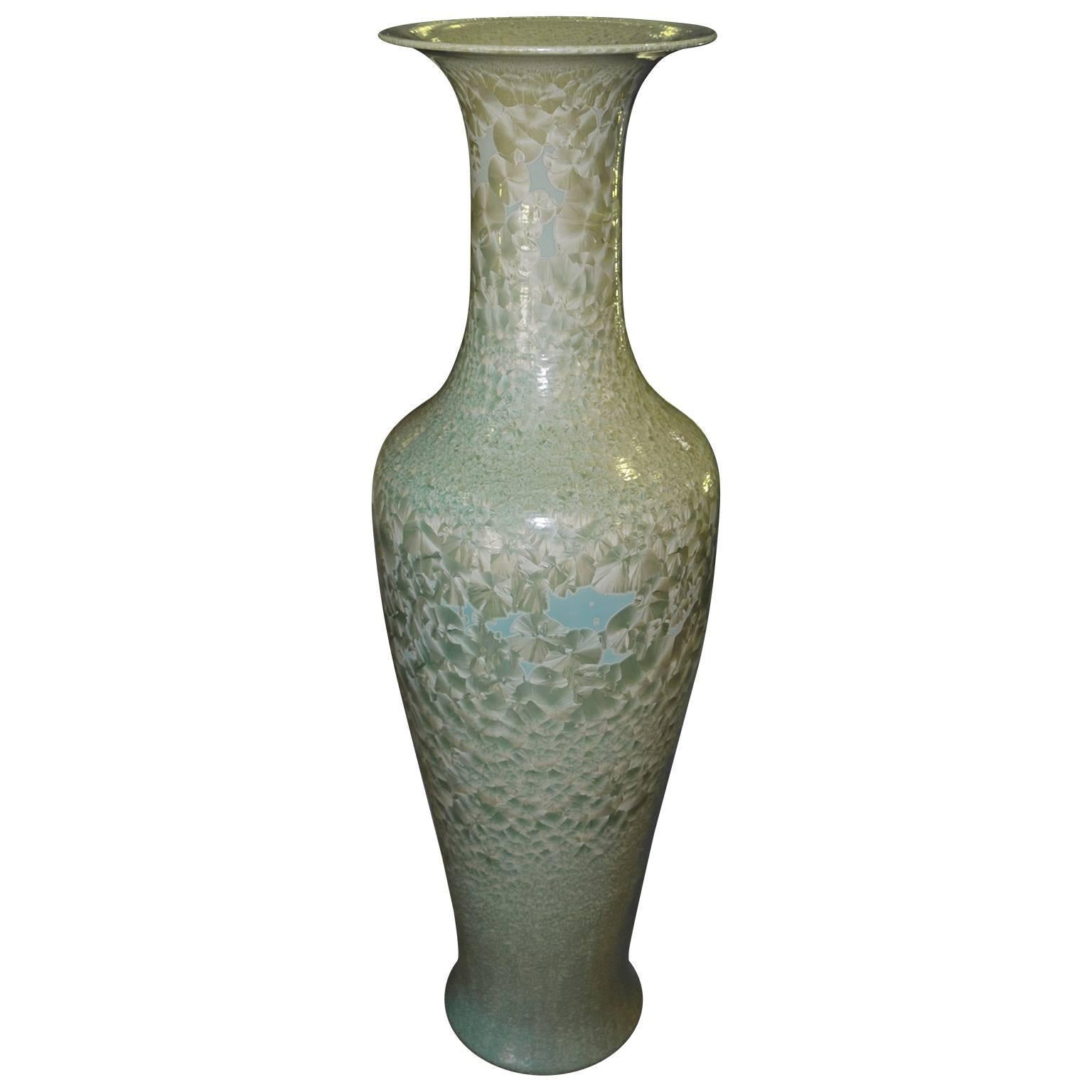 Set of three tall Celadon porcelain floor vases made in Hong Kong. These beautiful vases have different shades of light blue and light mint green through out the entire vase. The exterior is hand painted and glazed. Each vase is different in shape
