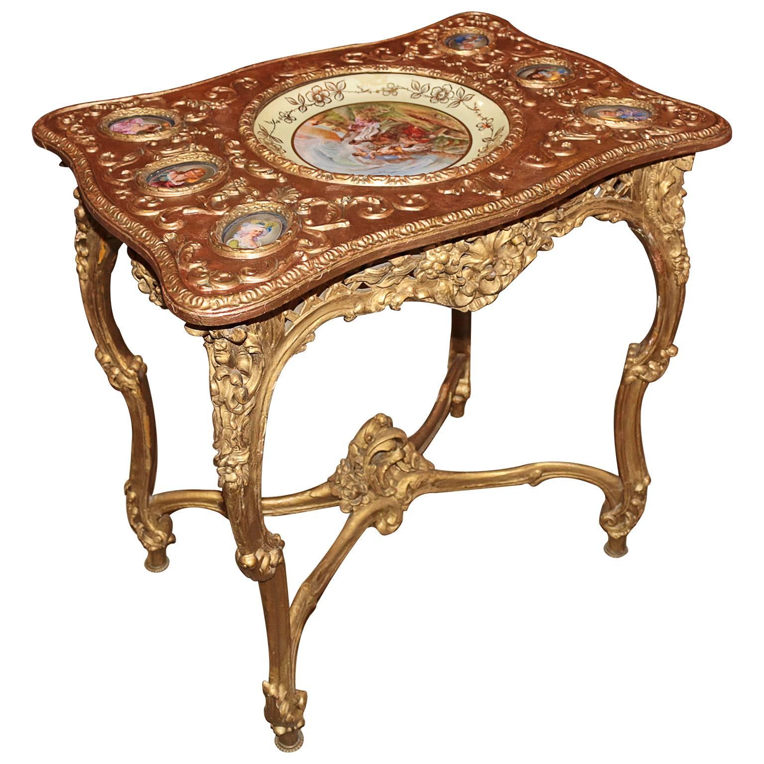 The beautiful curvy end table with six small porcelain hand-painted sevres plaques to both sides of one larger hand-painted center plate. The plaques are in great condition and have little to wear consistent with age. This end table has great