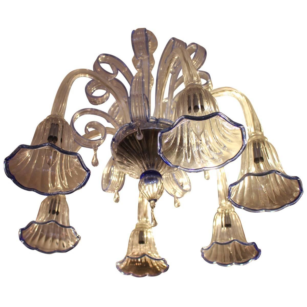 This stunning six-arm Murano glass chandelier has two tiers. The arms extend from the bottom tier upwards with the tulip tips extending downward. This Murano Chandelier will brighten up any space.