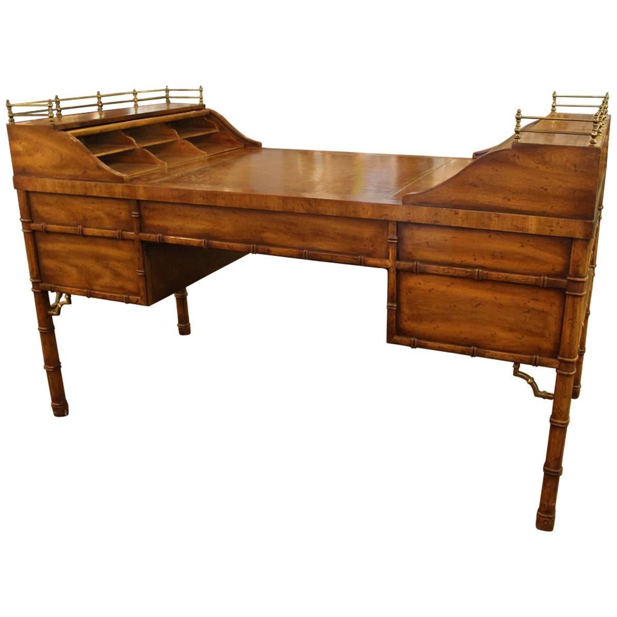 This amazing untouched desk made by Drexel Heritage is a George Washington style desk featuring a tooled leather writing surface and ample storage space for all necessities. Great George Washington style faux bamboo and brass desk with tooled