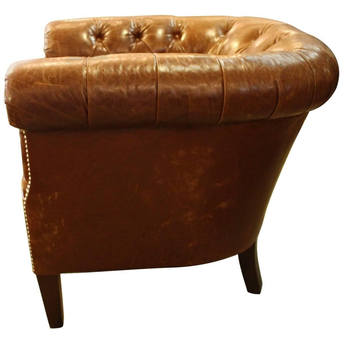 Made by Ralph Lauren, this club chair is upholstered in cognac leather with brass nail head detail. Adding an elegant touch to your home, it features a tufted back and smooth seat cushion. Ralph Lauren tufted leather club chair. The nail heads are a