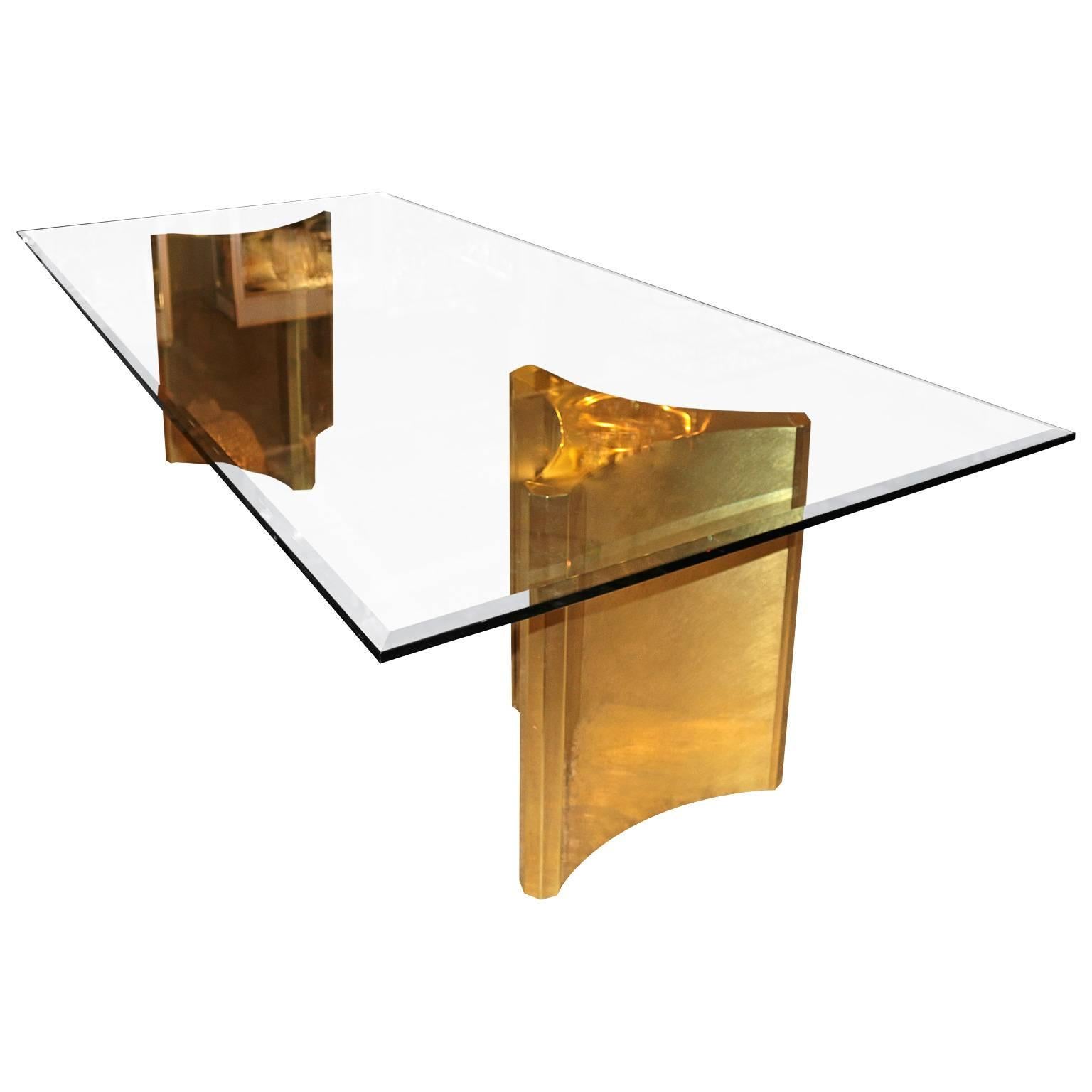 Stunning dining table by Mastercraft with a pair; brass pedestals. The table is newly polished and is in excellent condition, the glass is original and it has a gorgeous bevel to match its sleek look.