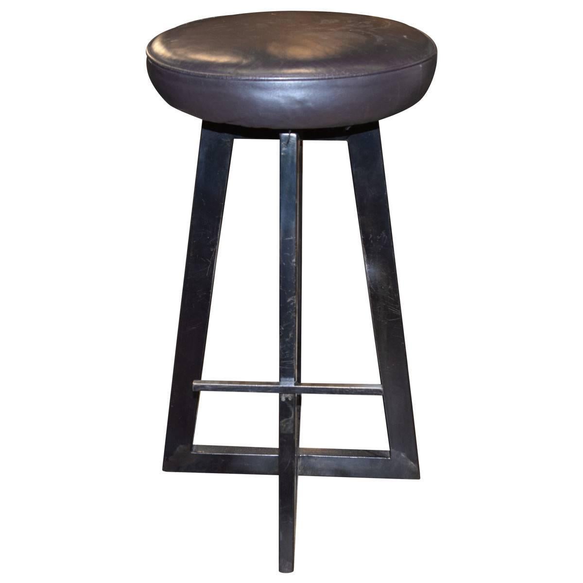 These vintage custom patinated iron stools stand on three legs and include a footrest. With leather-upholstered, swiveling seats, their clean, geometric lines would fit perfectly with a contemporary decorating scheme. Sold as a set of two.