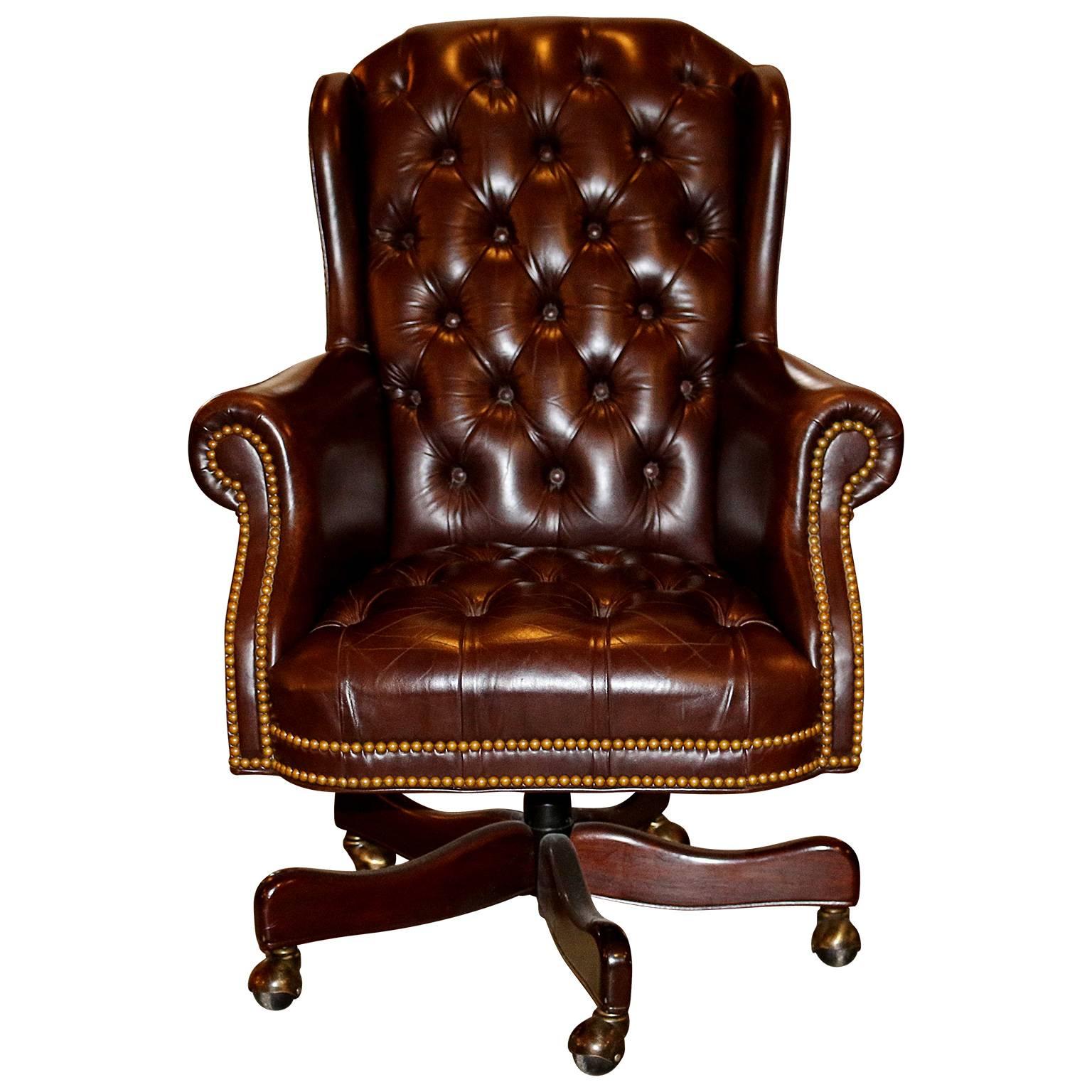 The Cabot Wrenn company of North Carolina, renowned for top craftsmanship and quality materials. This handsome traditional executive chesterfield rolling armchair with bronze nailheads has an adjustable seating. The seating is made from a beautiful