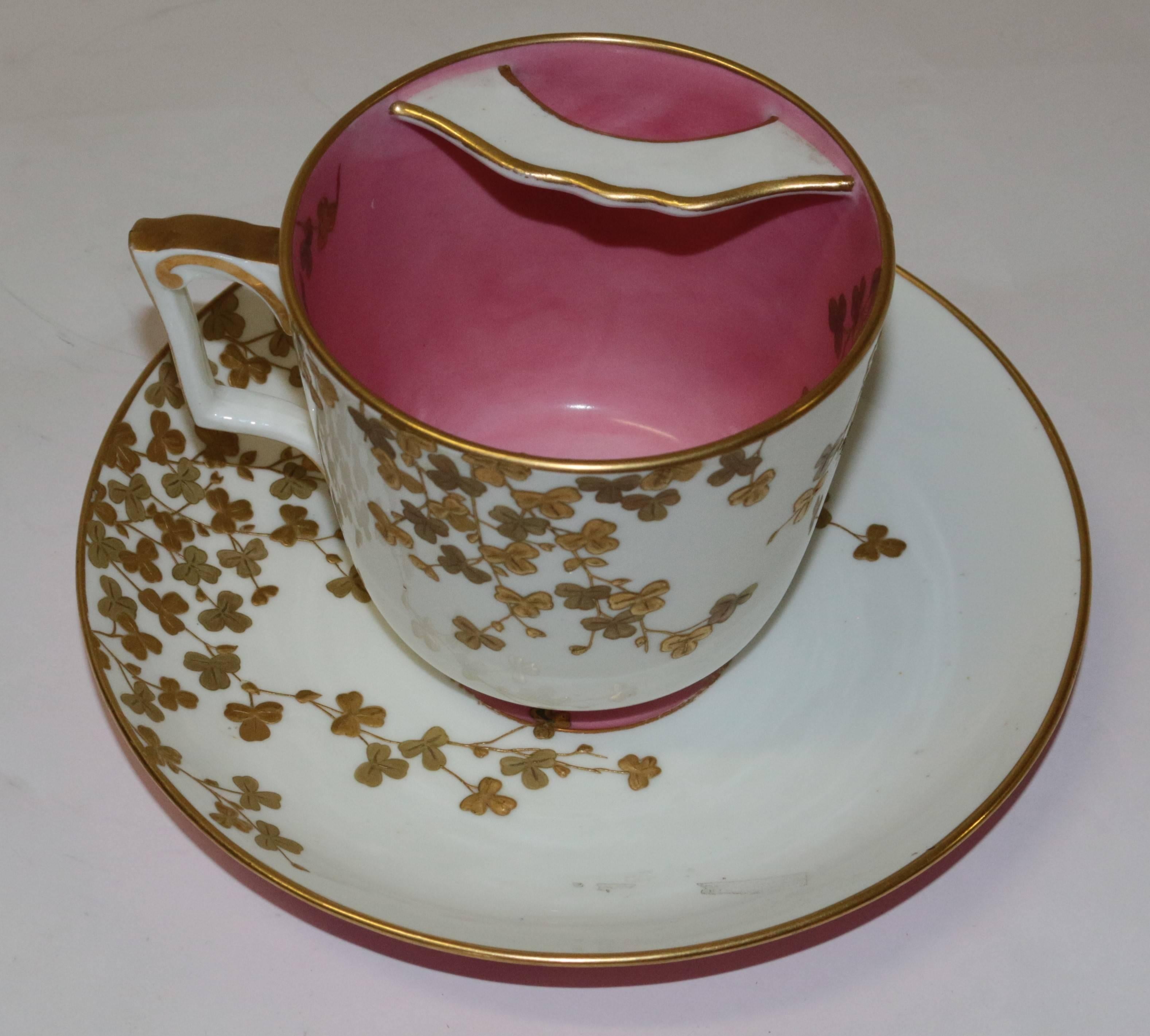 A large Tiffany & Co. moustache cup and plate, in glazed and gilt porcelain, the plate 8 ?" in diameter, and the cup 4 ¾" in diameter. The cup has a bright pink glaze inside, matching the centre of the plate and the back rim of the