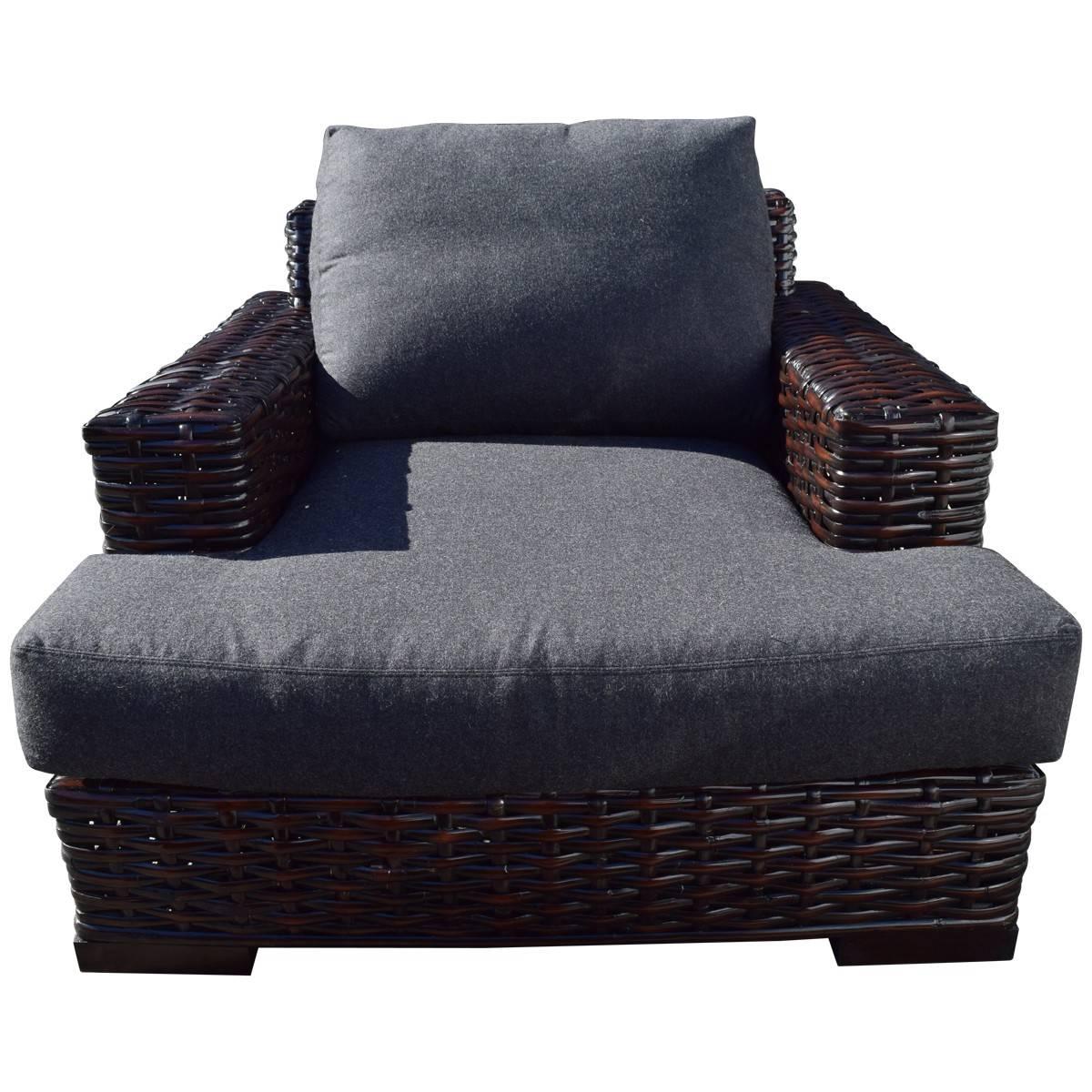 Ralph Lauren’s home furnishings and accessories reflect an enduring style and the same remarkable craftsmanship synonymous with his clothing. This armchair and coordinating ottoman have dark rattan frames and loose, down-filled cushions upholstered