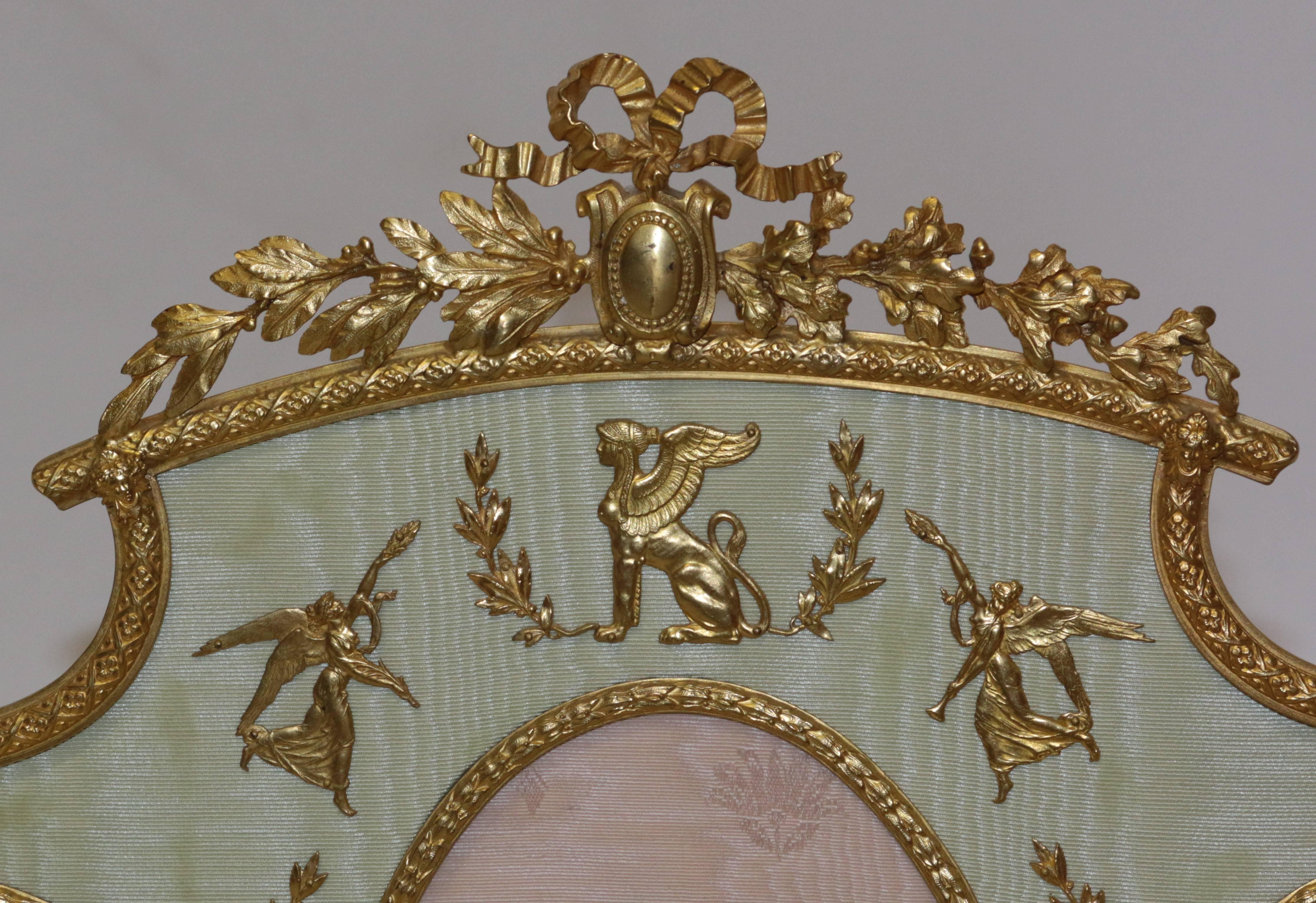 French multi picture ormolu frame. The figurines inside of the frame are made of bronze ormolu with great attention given to detail. The stand is made of bronze ormolu as well. This elegant item holds seven picture within the ormolu etched frames.