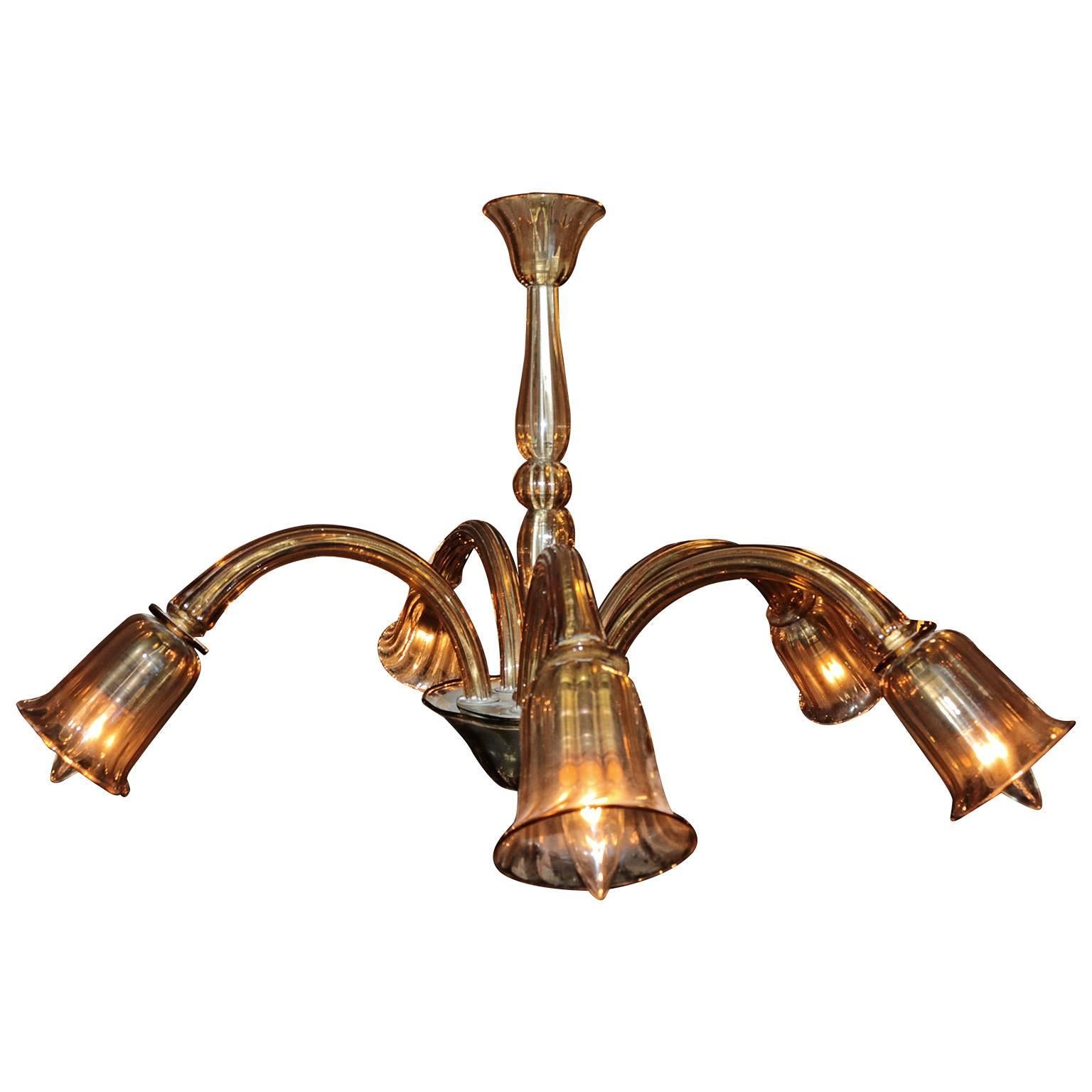 This beautiful five-arm handblown Venetian Murano with single tier chandelier in a transparent champagne color is in excellent working used condition. The arms are down right and are adjustable and may swivel to adjust for lighting. Comes with chain