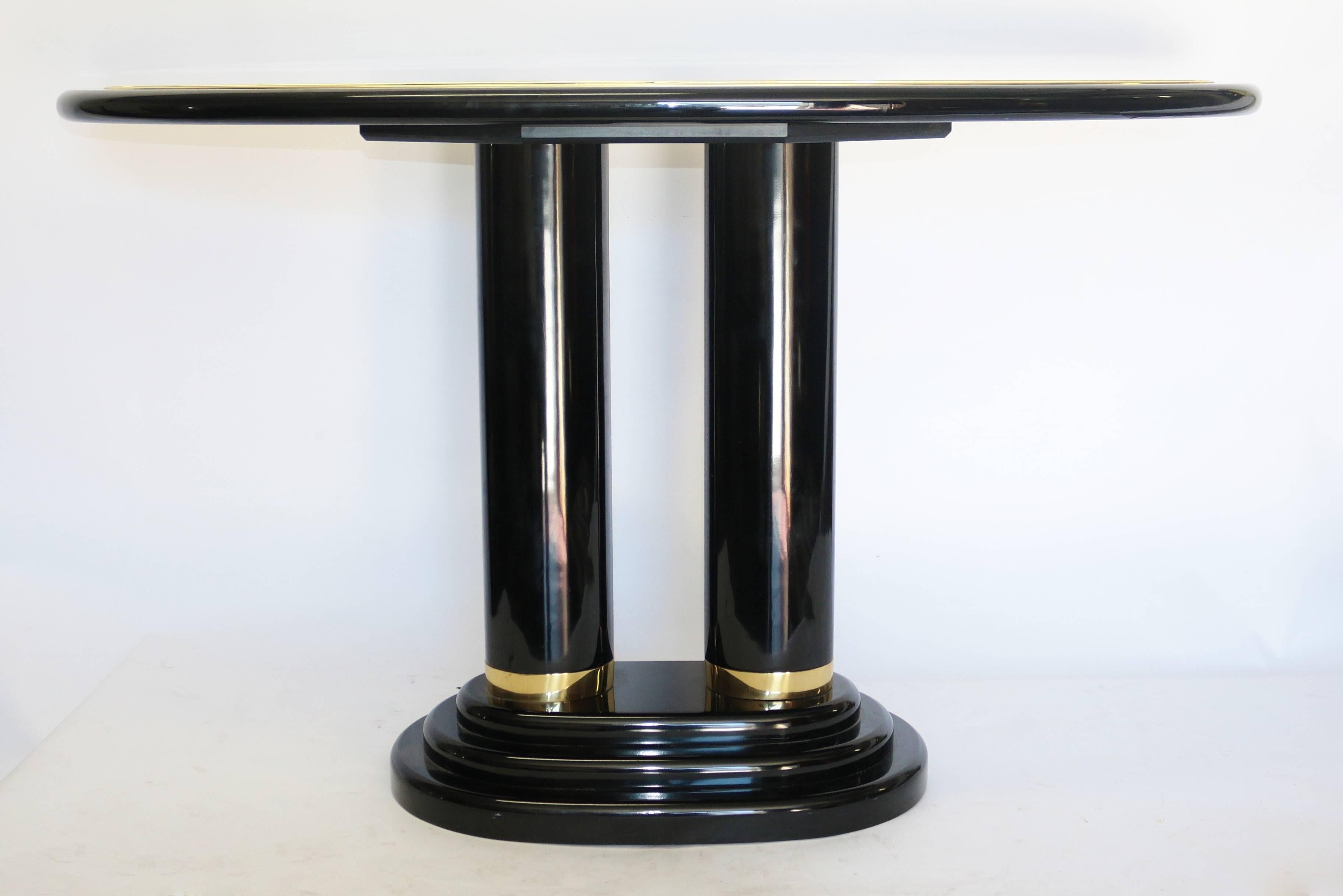 This elegant lacquer console table with a great modern feel. This tall pedestal console table has a beautiful thick brass trim and has black lacquer with brown lacquered top. This great modern pedestal console table has an elegant form factor with a