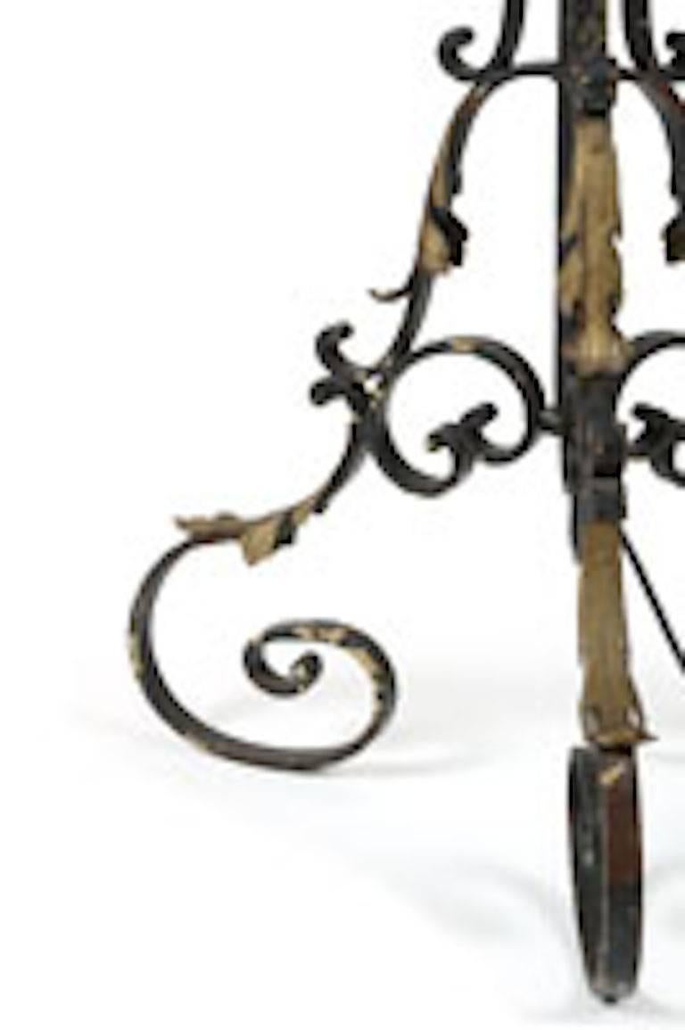 This beautiful Italian wrought iron standing floor lamp has beautiful molds. 20th century of scrolled tripodal form with gilt leaf embellished to the base. This lamp comes with a satin shade and it is in proper working order.