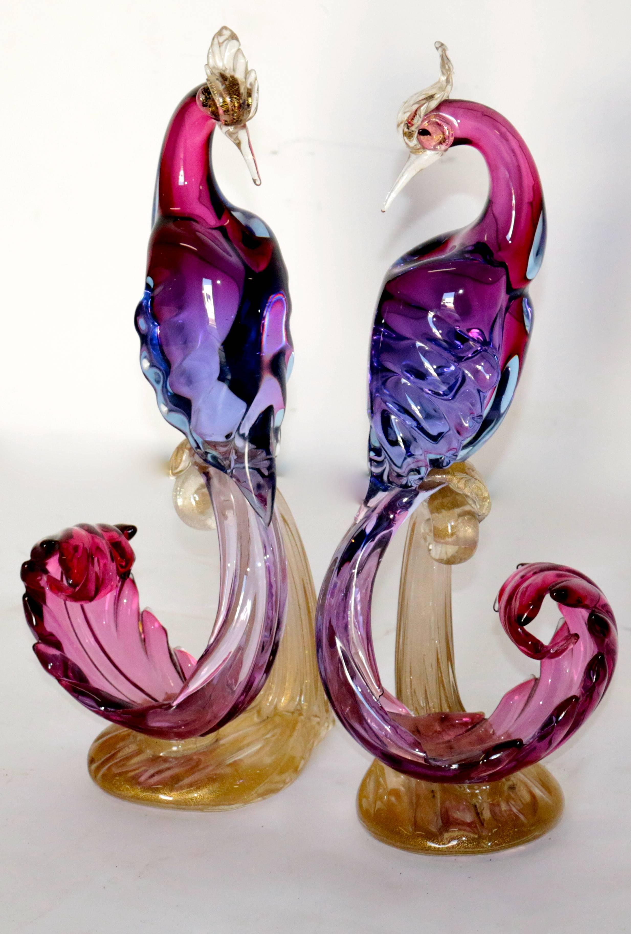 Pair of midcentury Murano birds of paradise with amazing color. These Murano birds show lush color. There are gold flecks throughout the entire base as well as the head of the birds. The center body shows curve the extravagant curves and the