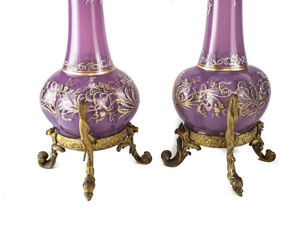 A fine pair of 19th century French or Italian purple art glass vases. A four sided bulbous formed base with raised gilt throughout. Bronze mounts to the top rim and bases. Partial Maker's Mark that are not recognizable.

Measures: Approx., 6