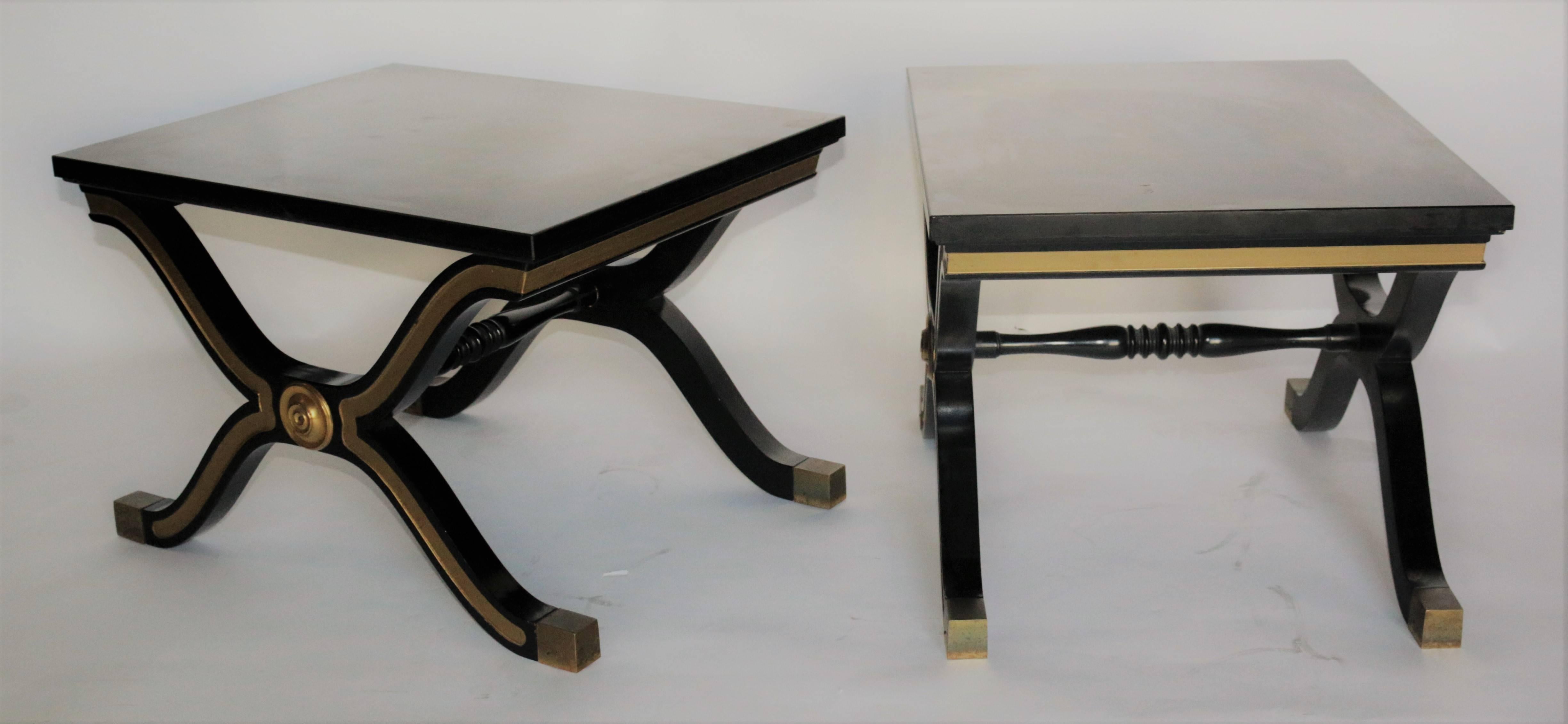 Modern pair of vintage Dorothy Draper side tables in great condition. The color schemes is a deep black lacquer with golden accents following the layout of the body. There are brass fittings on each leg at the tip of the foot and there are
brass